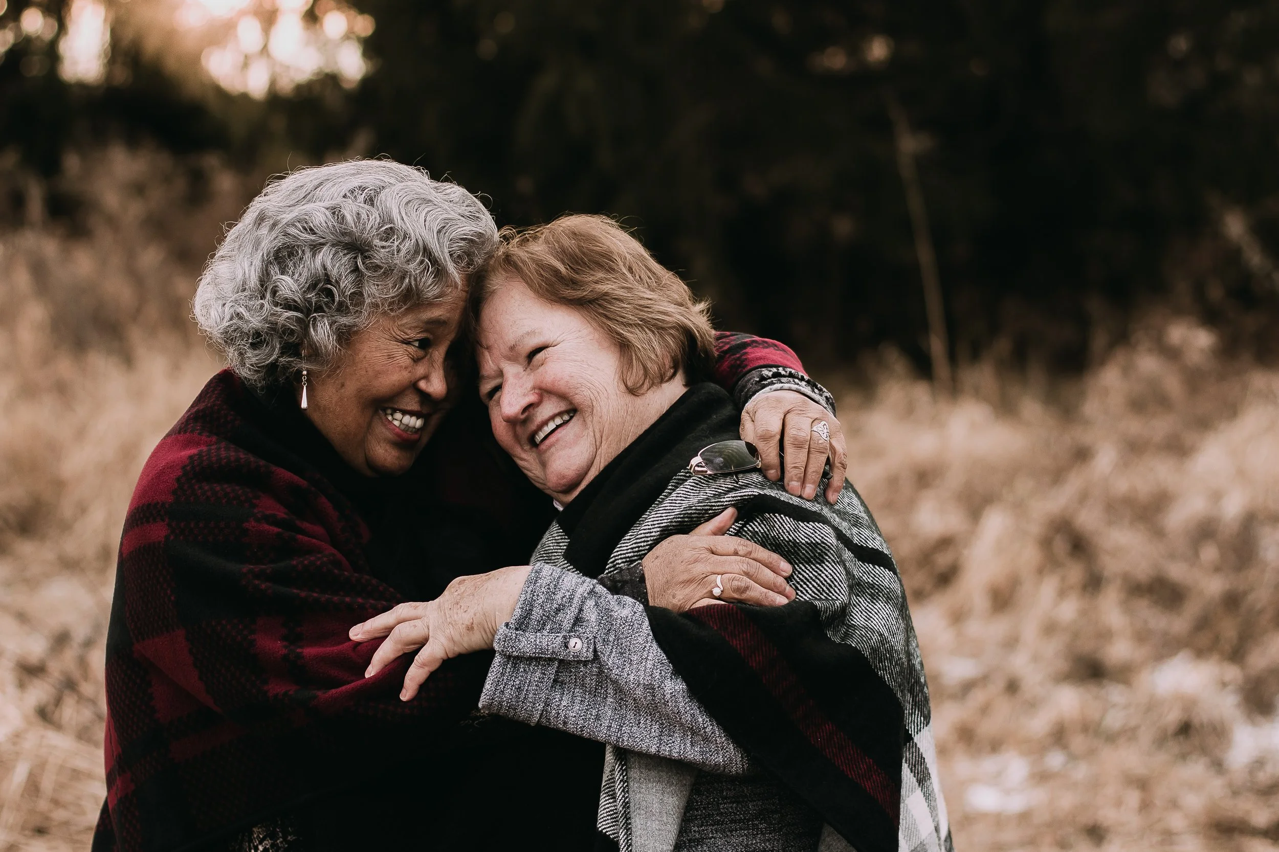 Elsa and Karen Ann both Eliana hugging outdoors, smiling and sharing a joyful moment.