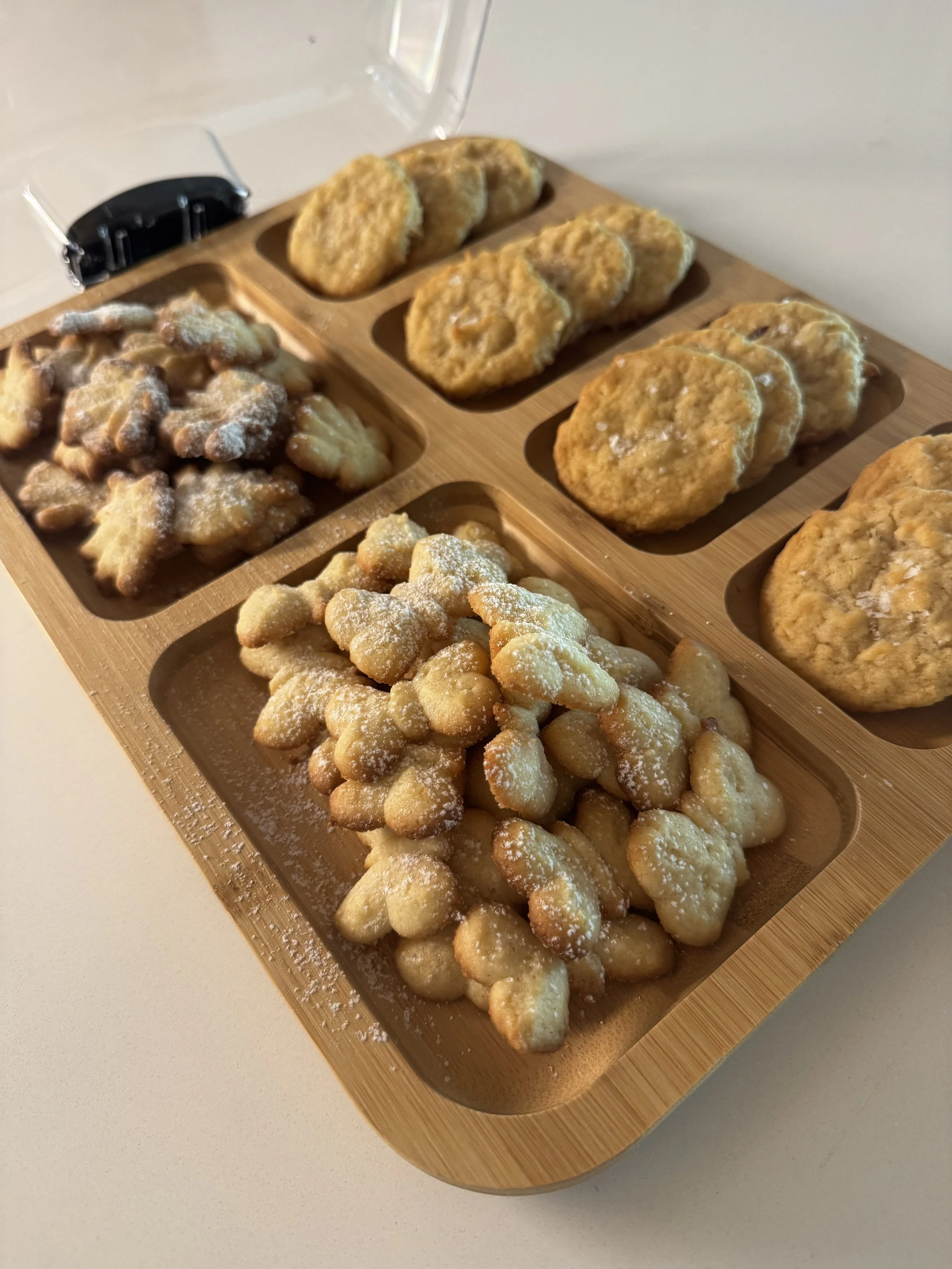 Assorted fried mini donuts and fritters on a wooden serving platter.