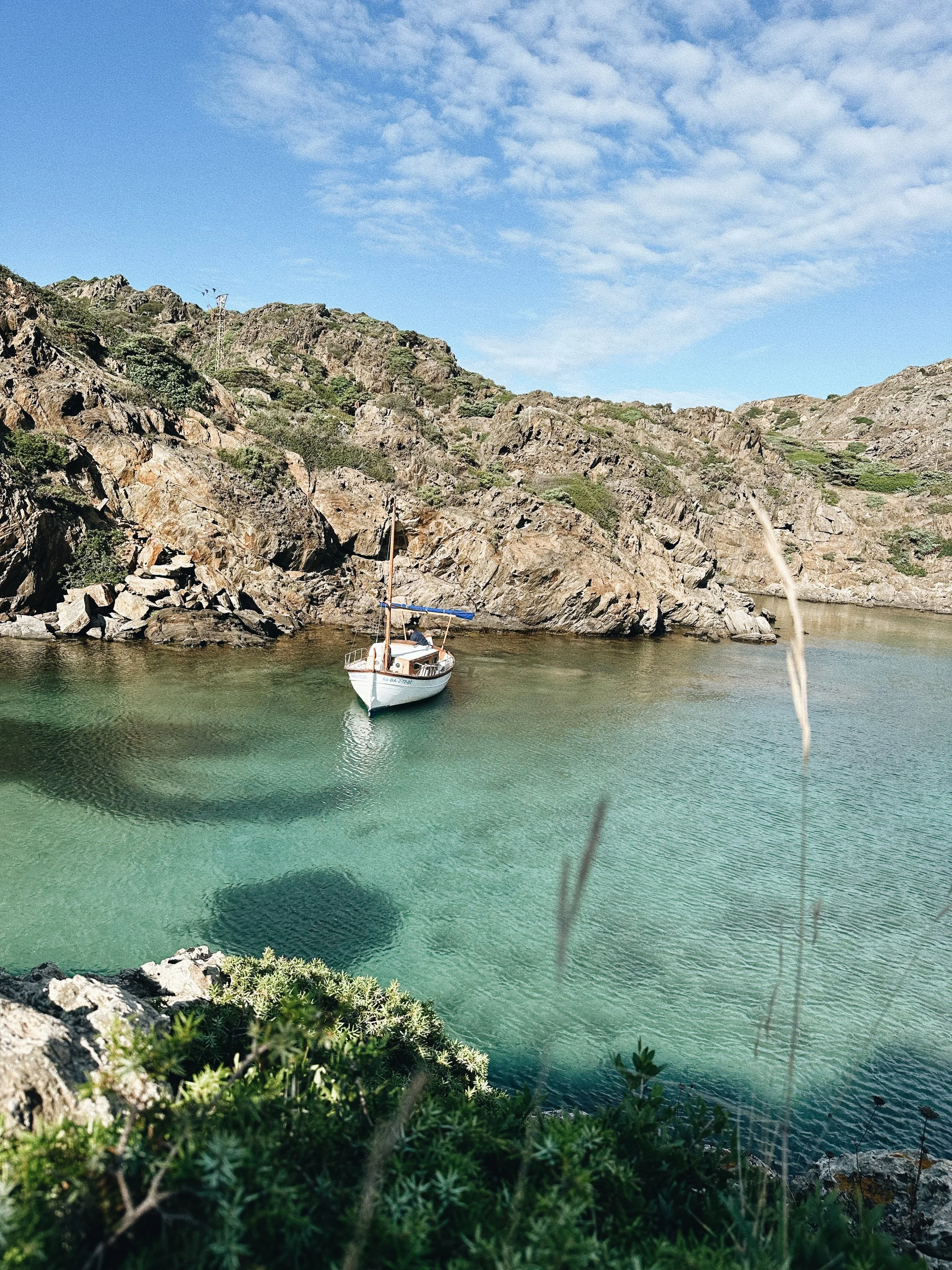 Barco fondeado en una cala de aguas turquesas del Cap de Creus