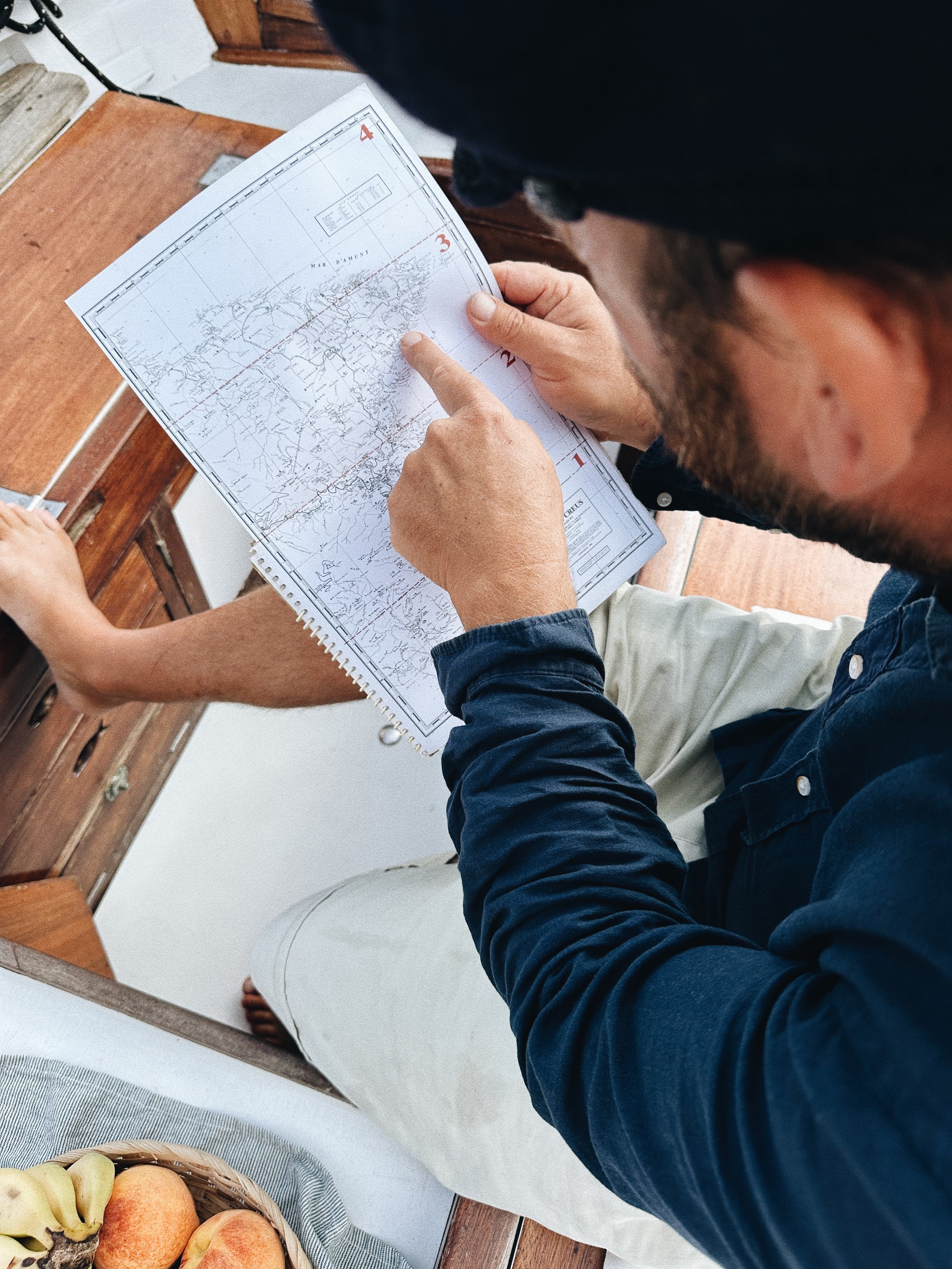 Barco tradicional navegando frente al pueblo de Cadaqués