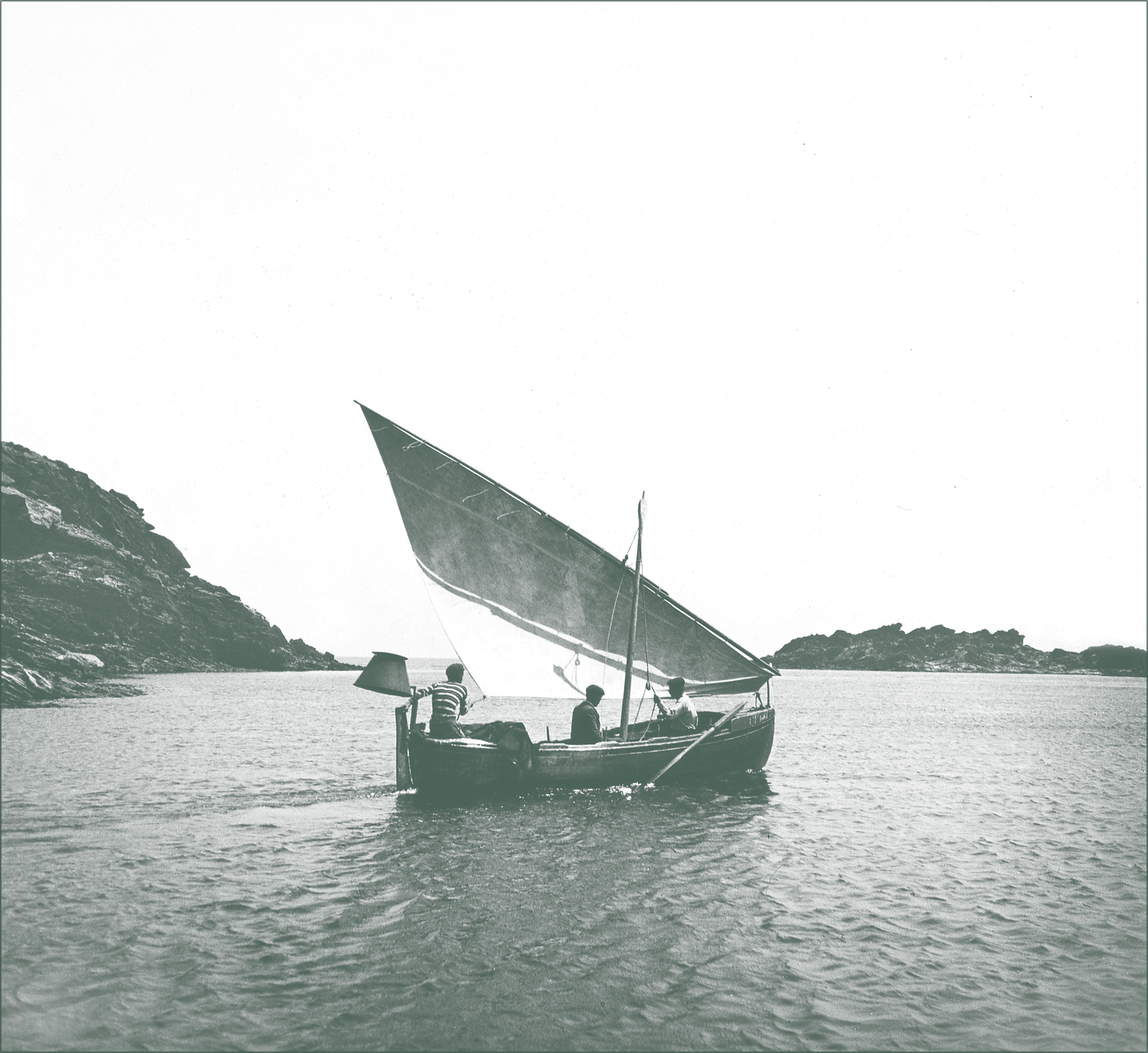 Llaut con vela latina navegando frente a la costa de Cadaqués, símbolo del patrimonio marítimo mediterráneo.