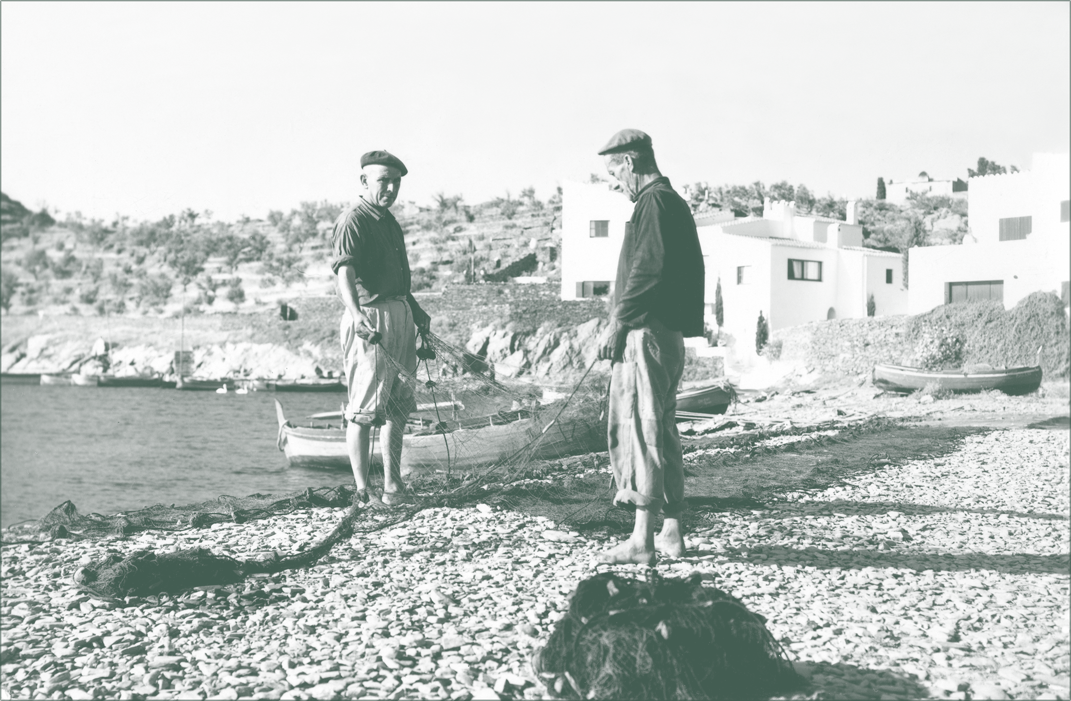Escena histórica de pescadores en la costa de Cadaqués con el pueblo al fondo, reflejo de la tradición marinera local.