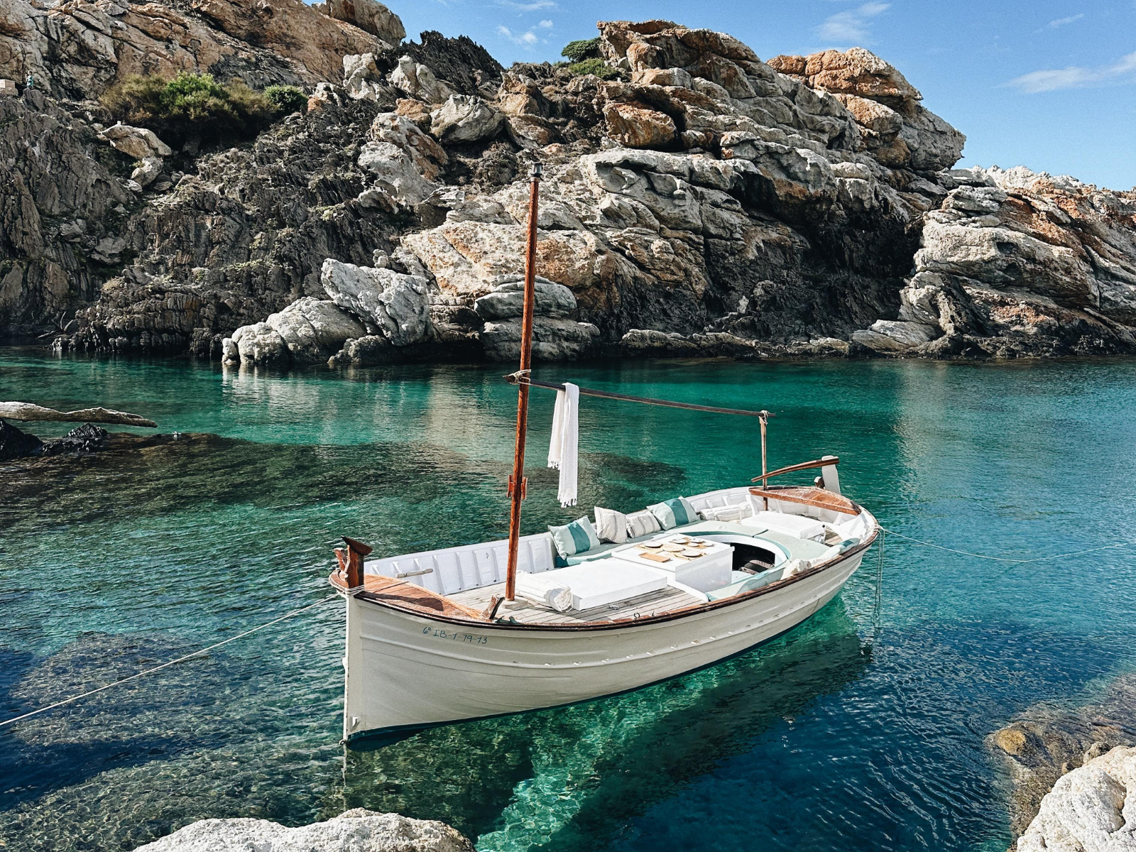 Llaut Es La Vida fondeado en una cala de aguas cristalinas del Cap de Creus en Cadaqués