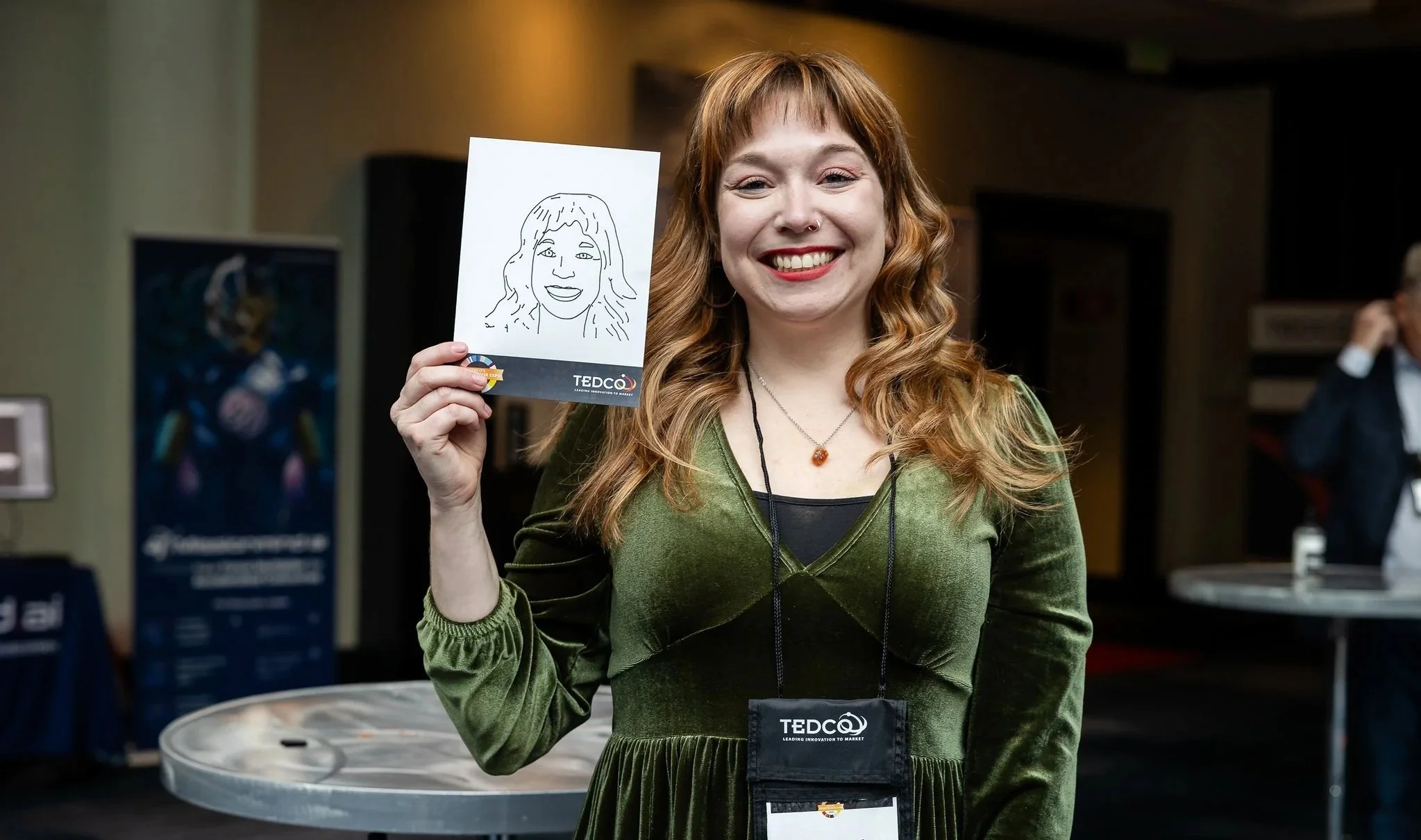 A happy sketchbooth user in green dress shows off her newly printed sketch