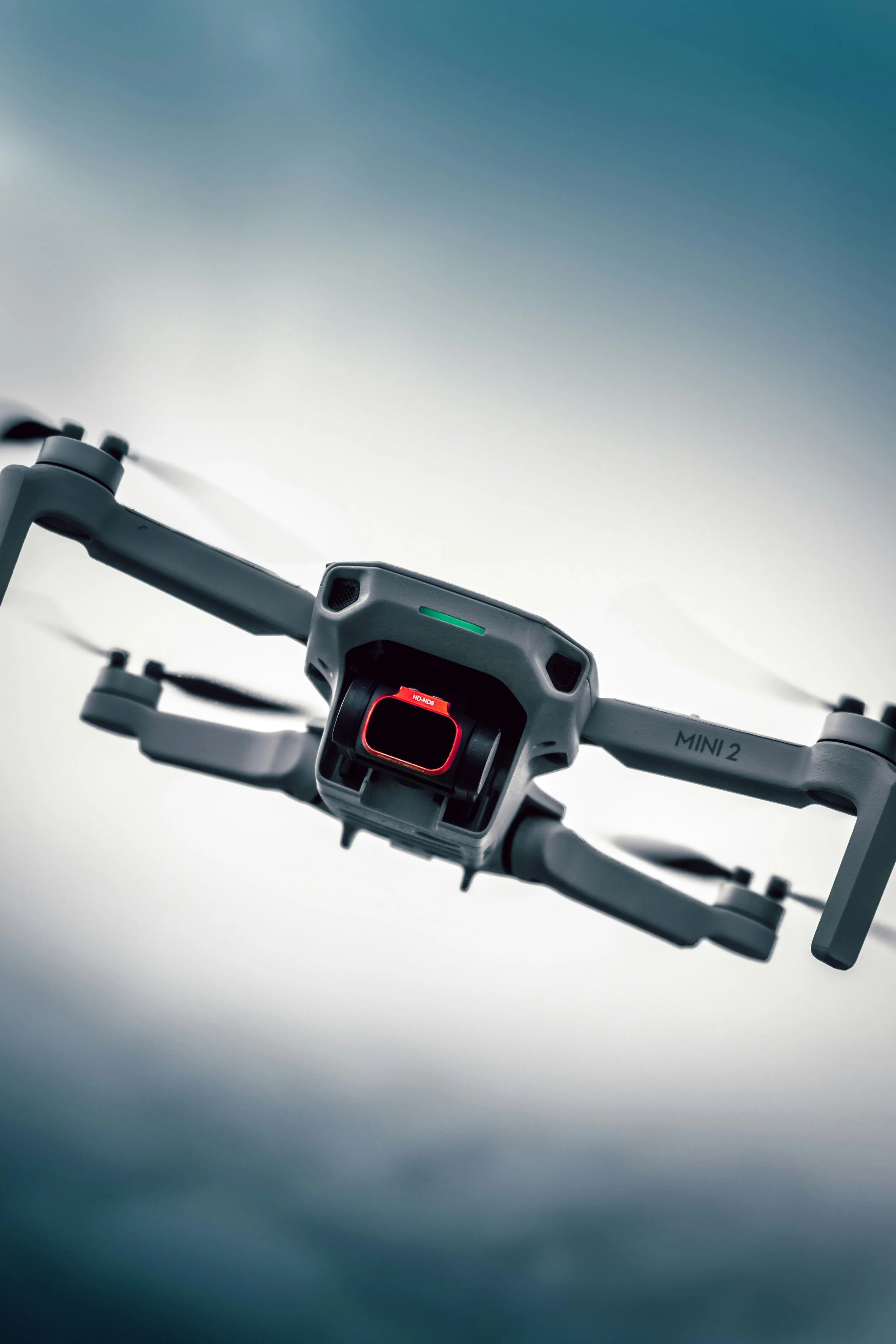 A drone with a camera mounted on its front, labeled 'MINI 2', flying in the sky.