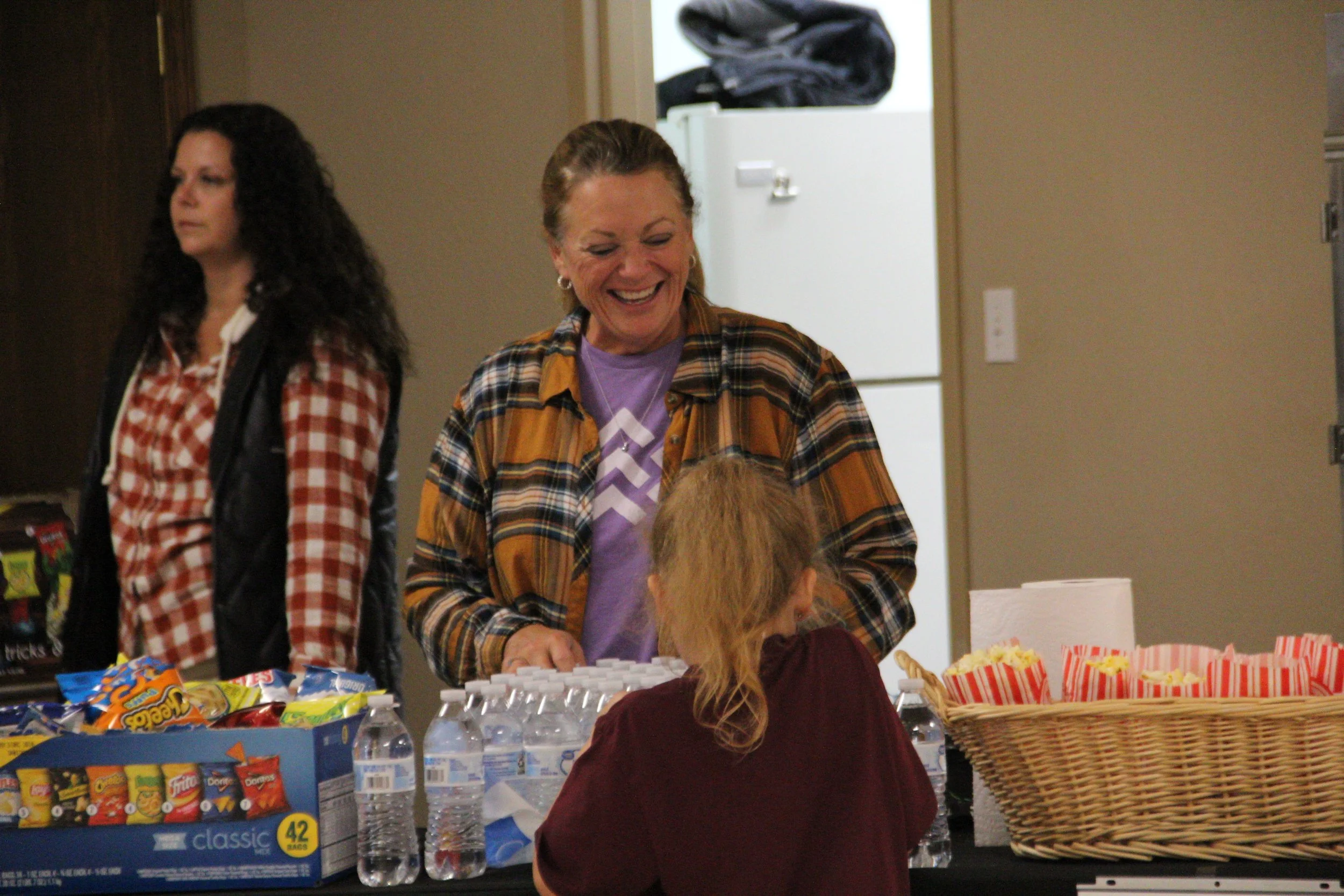 Volunteers offer snacks and bottled water to neighbors at a community event