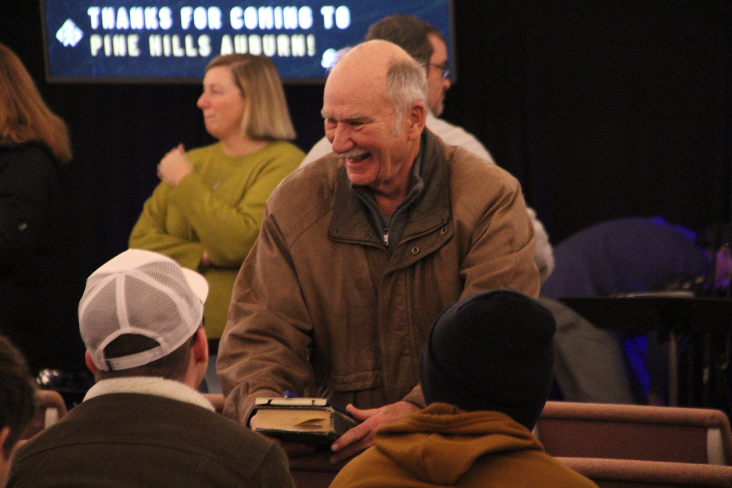 A church member carrying a Bible greets others at Redeemer City Church