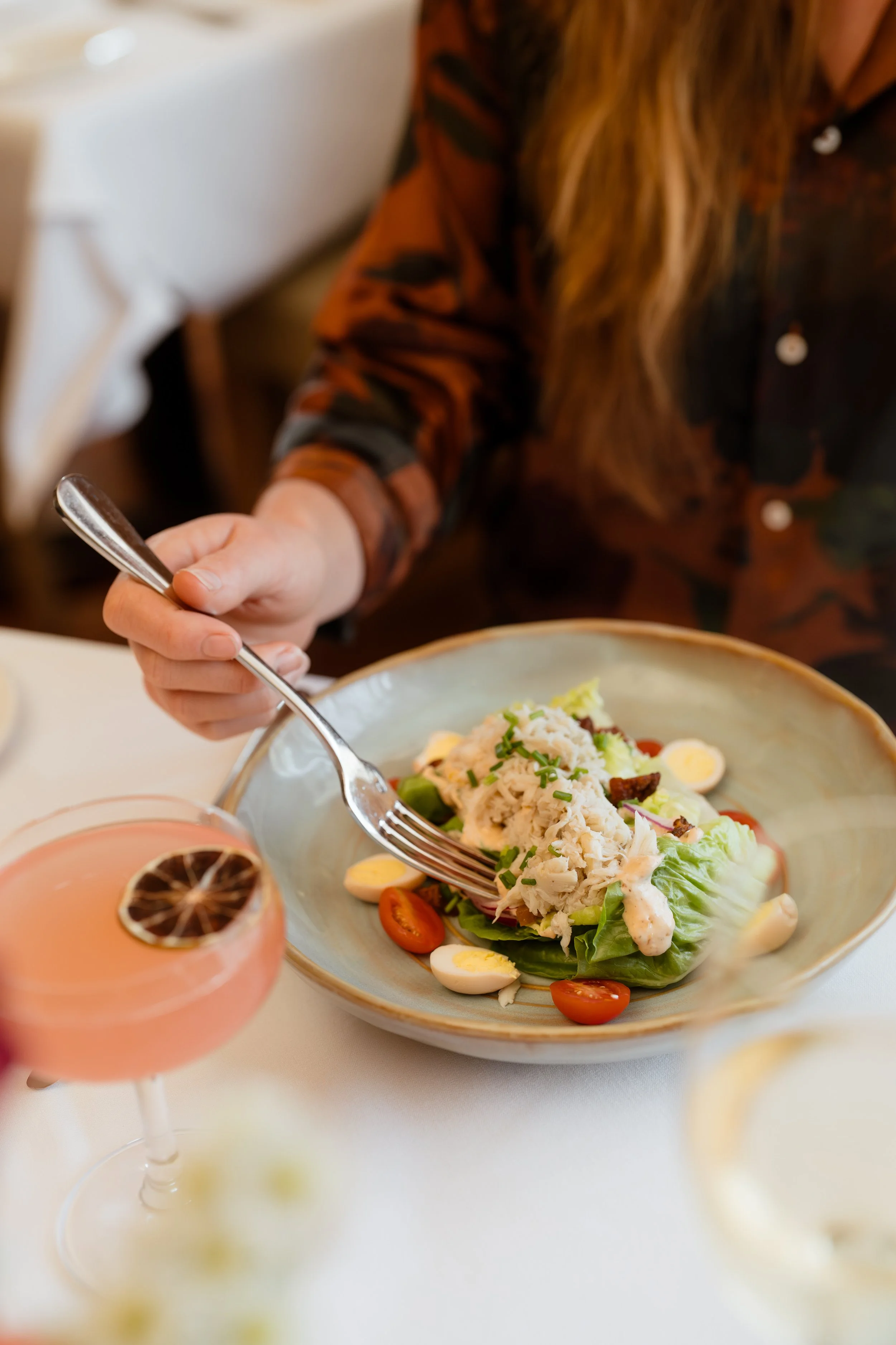 Woman with fork in salad with crabmeat and cocktail.