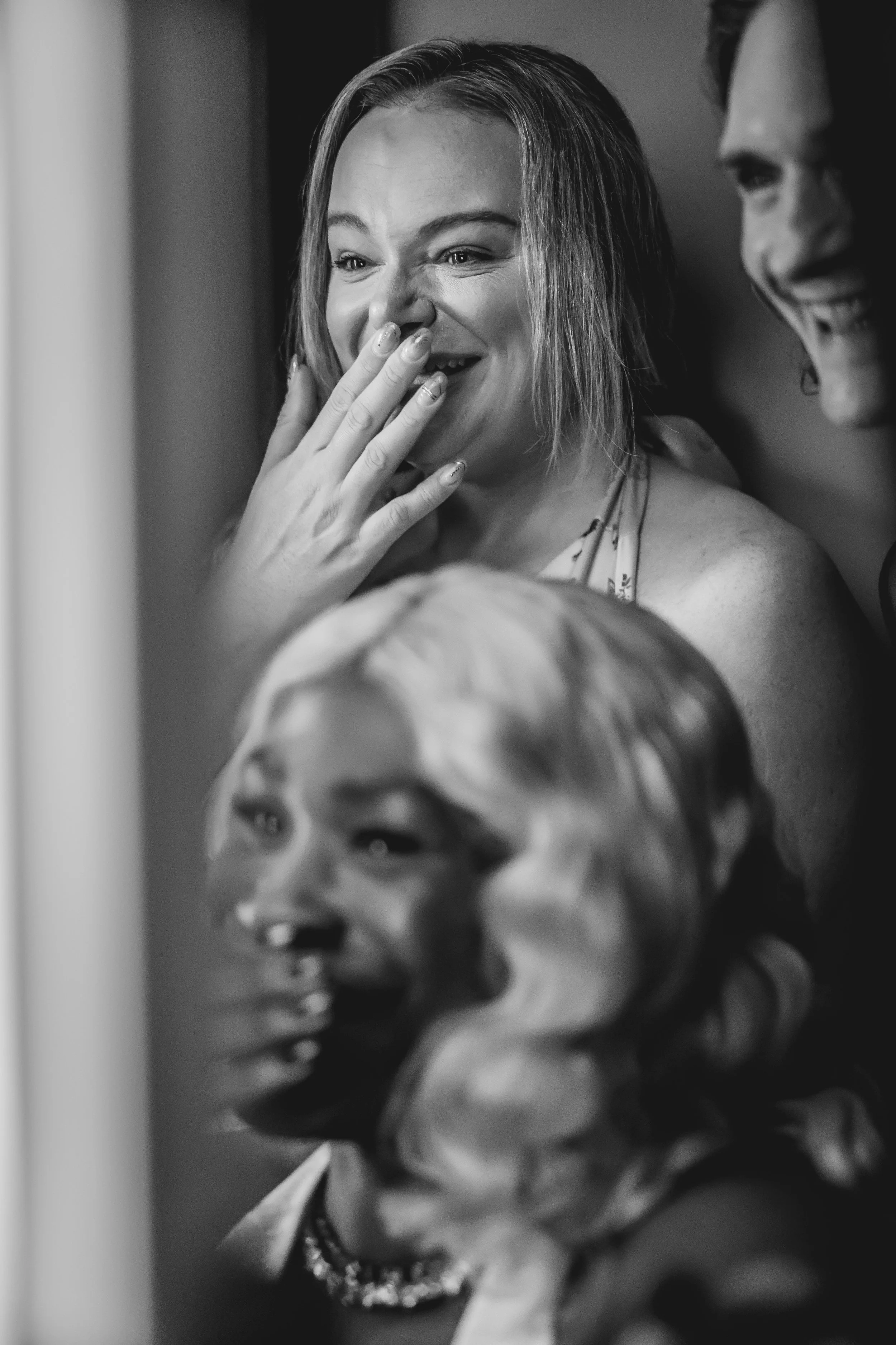 Three people laughing in a photo booth.