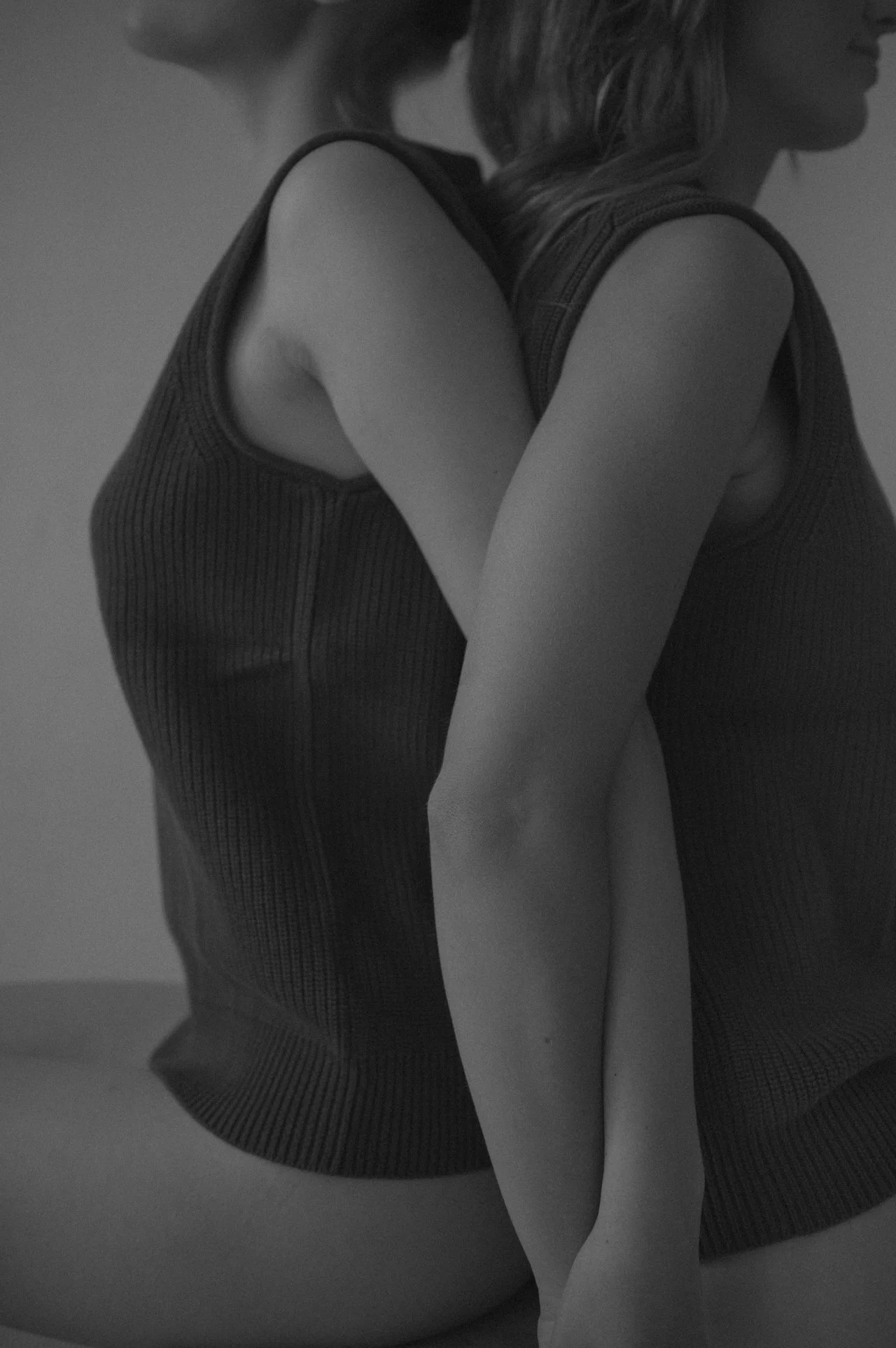 Two executive assistants in Winnipeg sit back to back after a day of admin assistant work cleaning inboxes, creating invoices, payment tracking, and errand running