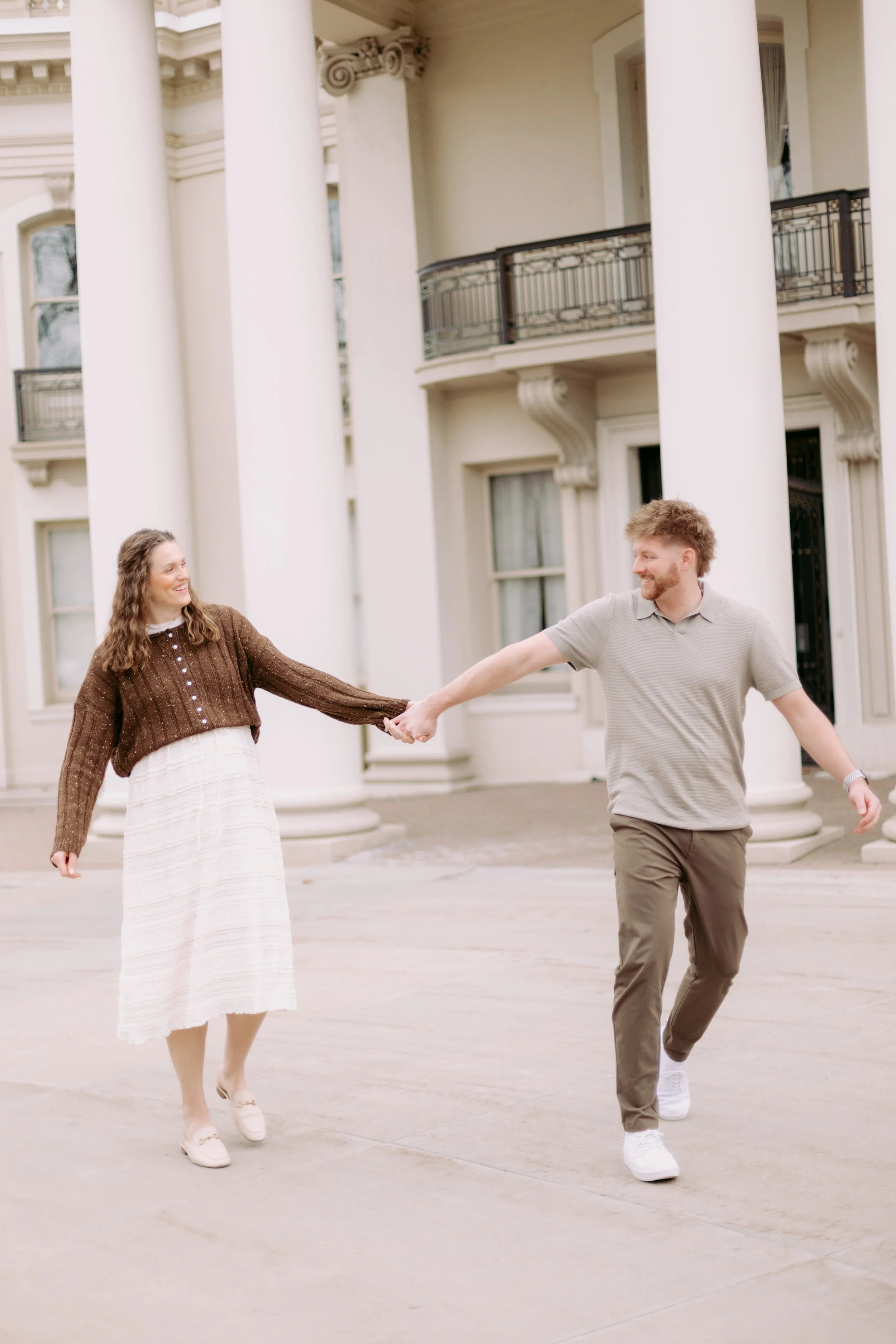 candid couple holding hands outside.