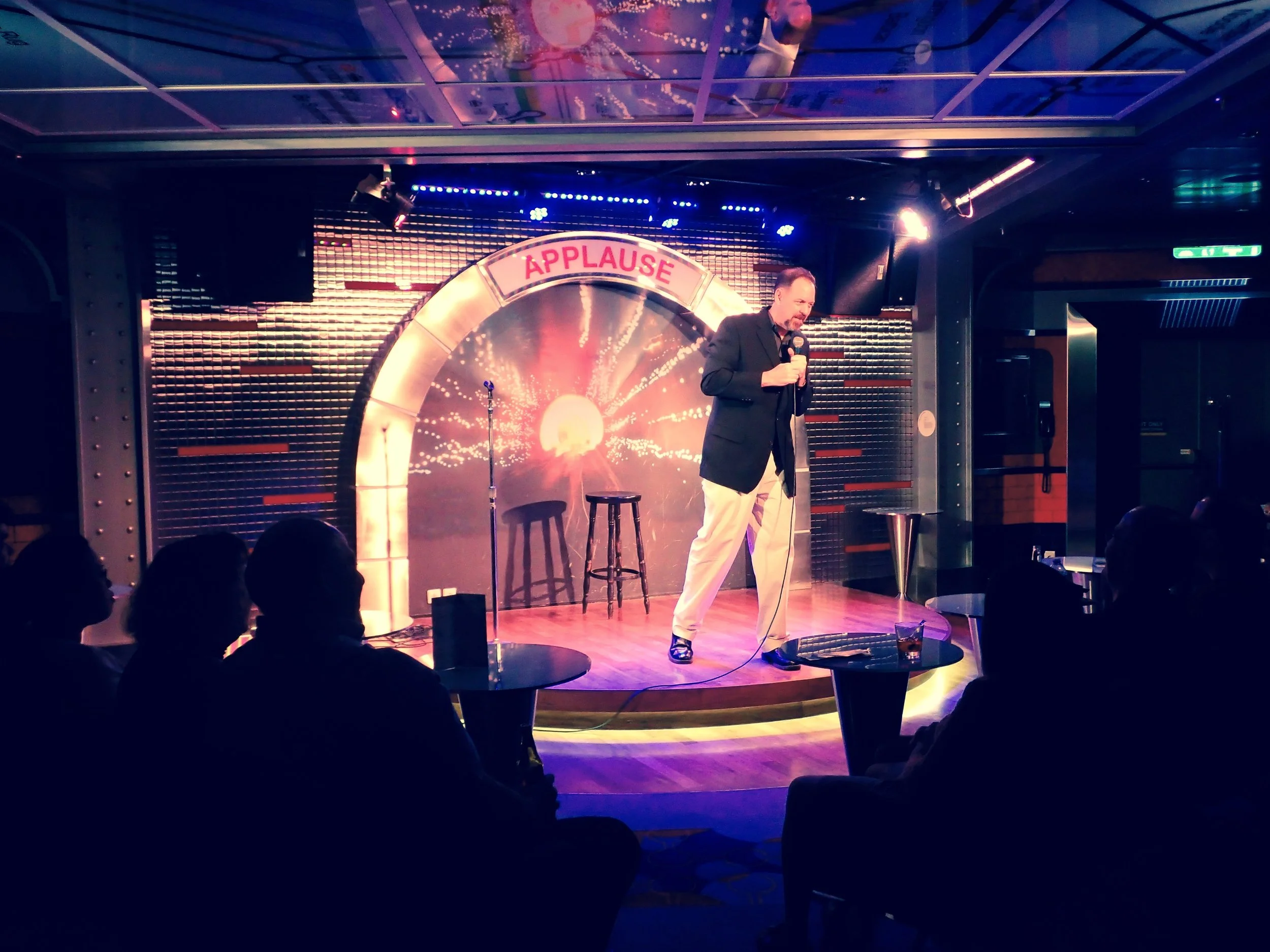 Comedian Jim McCue performing live for an audience during a professional comedy show.