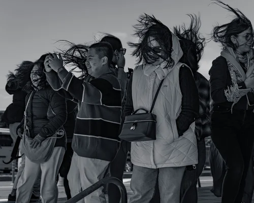 A group standing together outdoors, their hair caught by the wind, Hakone, in black and white.