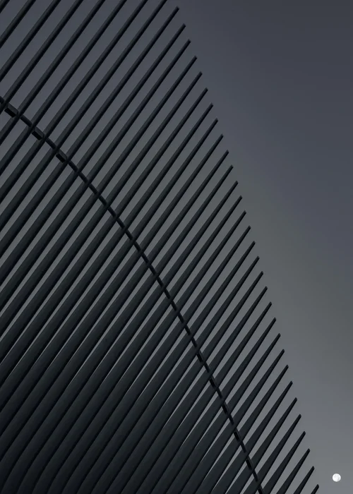 A close, abstract study of a dark building facade in New York, its ribbed diagonal lines filling the frame in black and white.