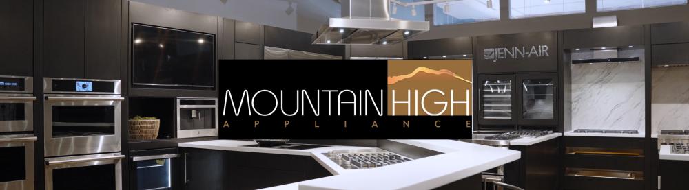 Kitchen display with appliance showroom, including built-in ovens, a microwave, and a stove, with a sign that reads 'Mountain High Appliance'.