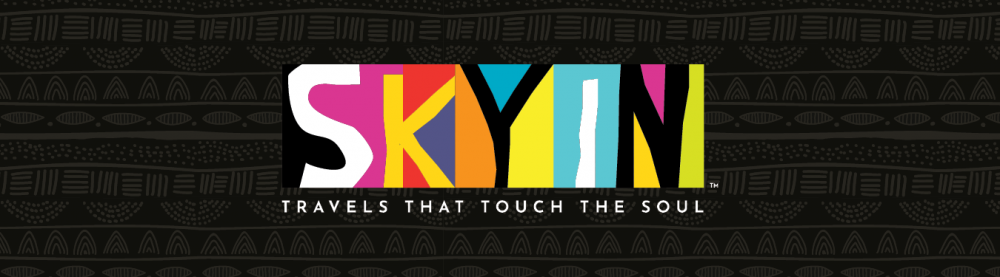 Colorful logo of Skyn with the tagline "Travels That Touch the Soul" on a black patterned background.