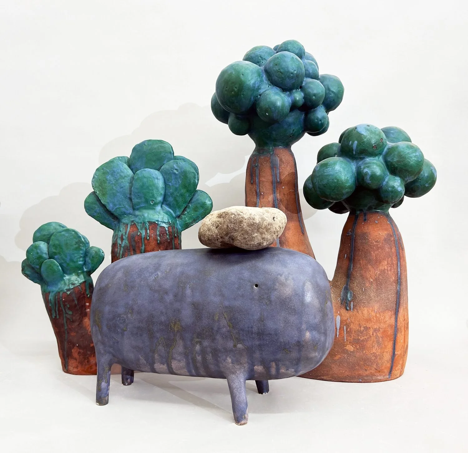  Fauna #3, 2022 (front)  Ceramic and wood  12 × 15 × 7 inches    Flora #4, 2022 (back left)  Glazed ceramic  17 × 14 × 5 inches    Flora #6, 2023 (back right)  Glazed ceramic  23 × 14 × 9 inches 