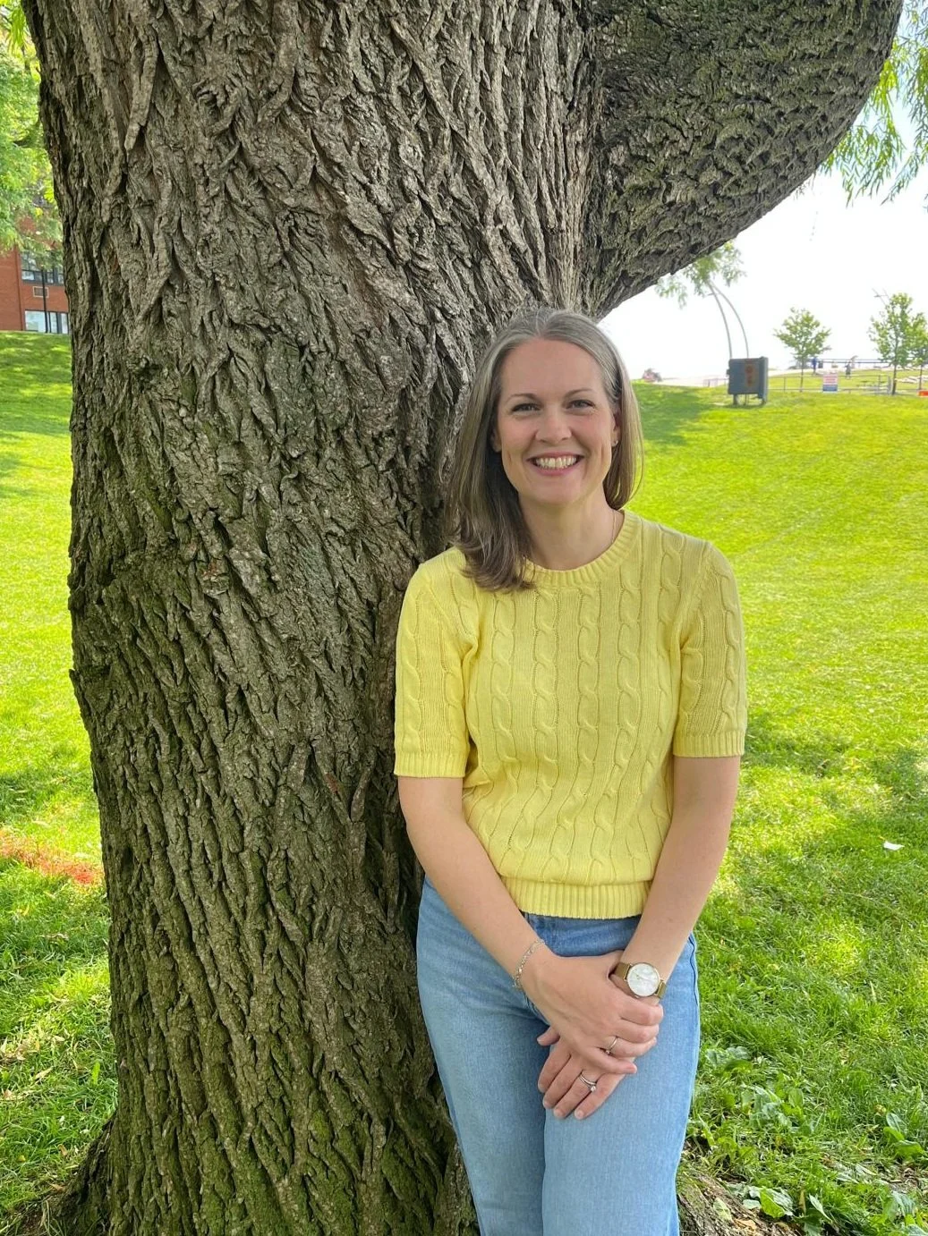Rebecca Civiero, copywriter, standing by a tree in Spencer Smith Park, Burlington, Ontario.