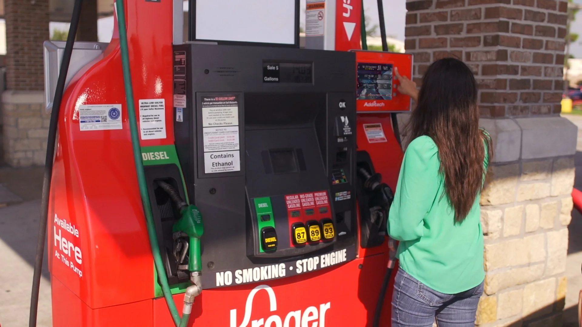 Driver selecting premium fuel additive option on fuel pump display during checkout