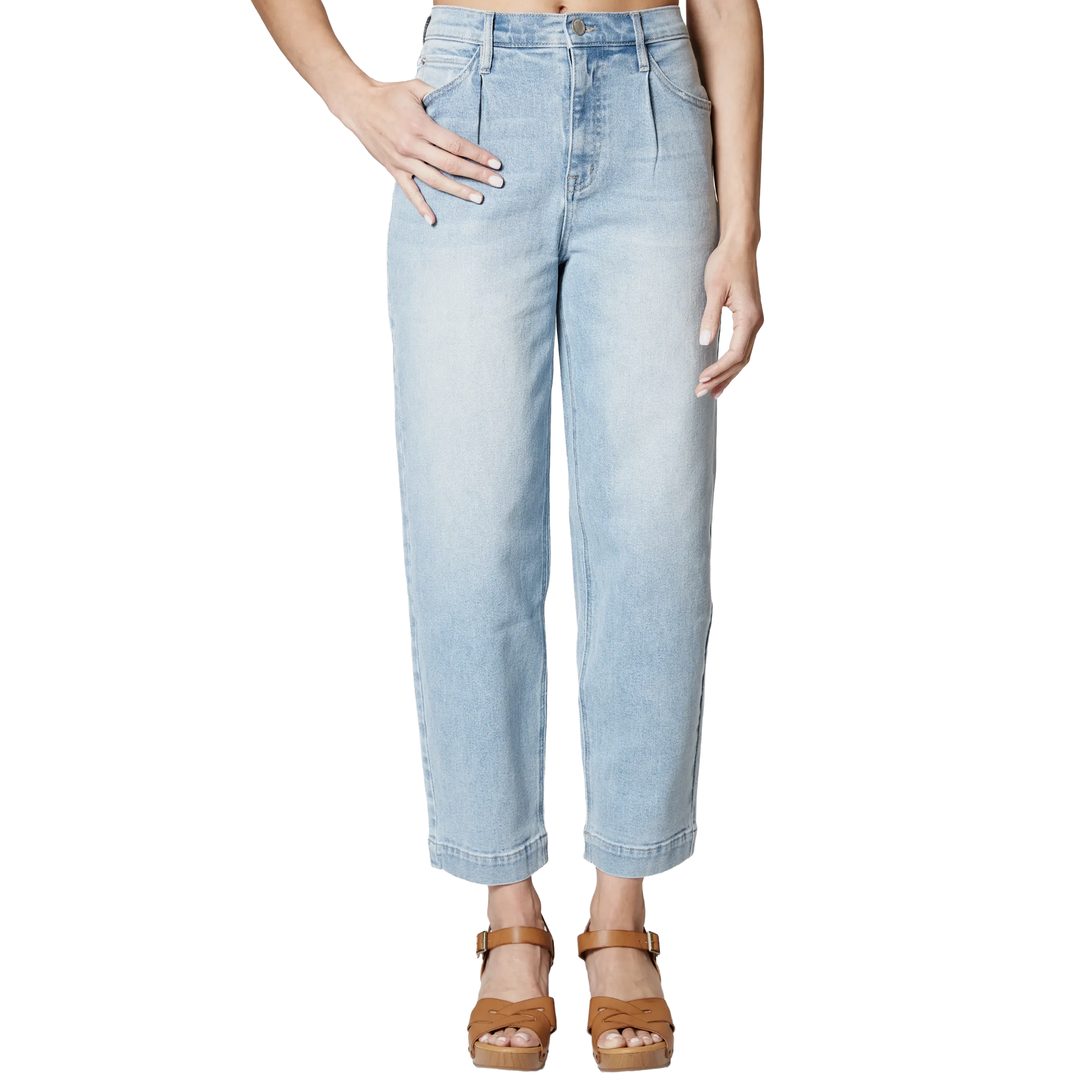 A woman wearing light blue high-waisted jeans and brown platform sandals, standing with one hand in her pocket and the other relaxed by her side.