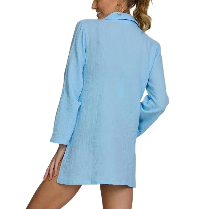 A woman wearing a light blue blazer with a textured fabric, seen from the back, smiling with her head turned slightly to the side.