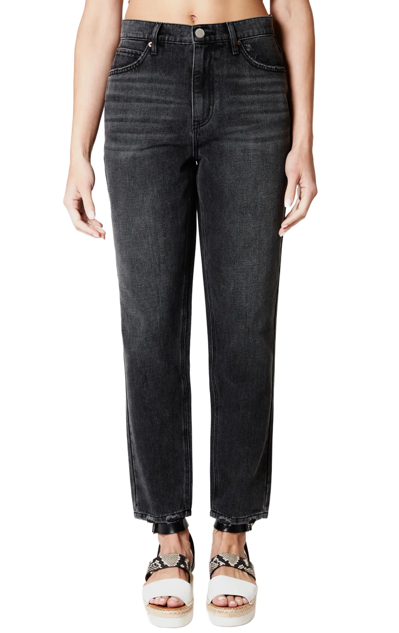 Close-up of a person wearing high-waisted black jeans and platform sandals with snake print straps.