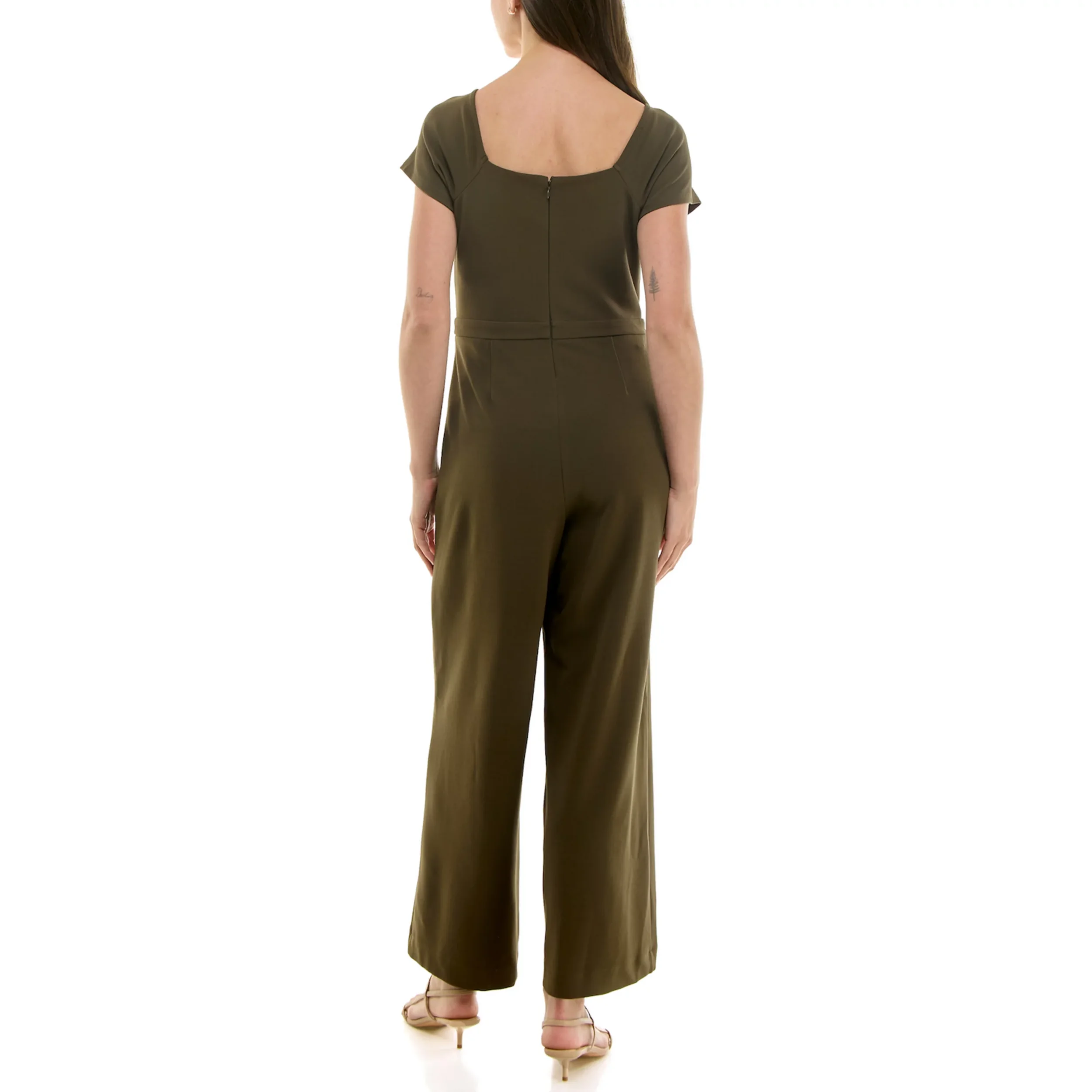 Back view of a woman in an olive green jumpsuit with short sleeves and wide-leg pants, standing against a white background.