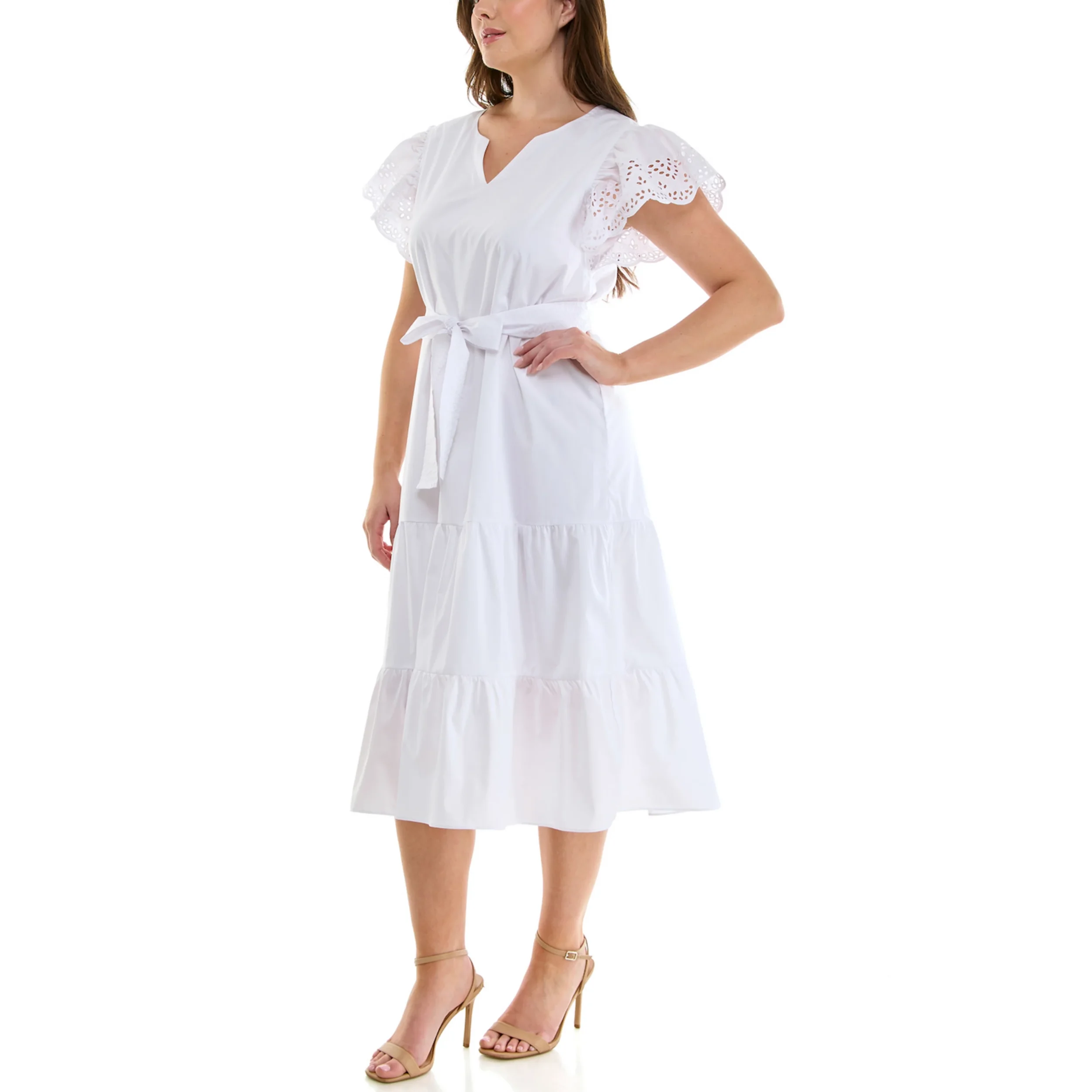 Woman wearing a white midi dress with ruffled sleeves, a waist tie, and tiers, paired with beige high-heeled sandals.