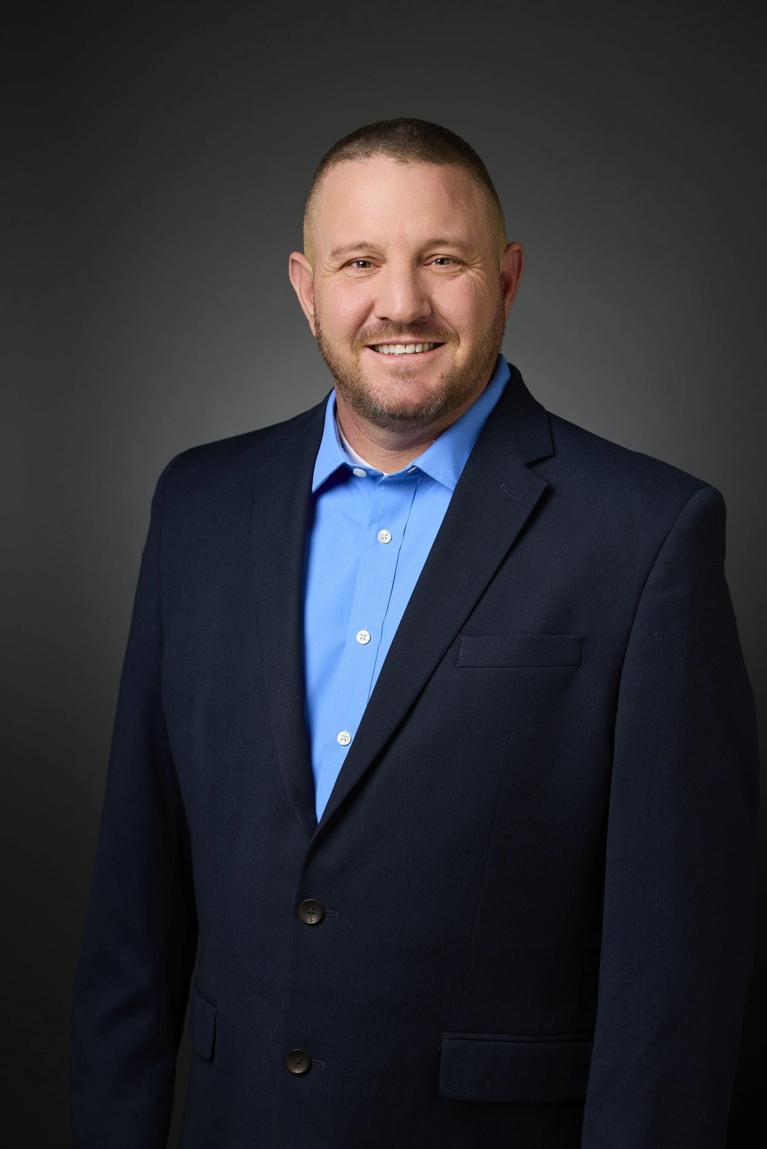 Smiling man against gray background.