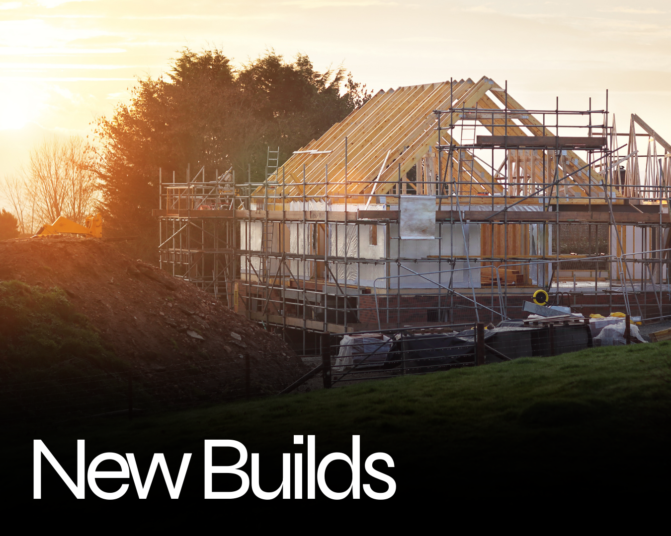 Construction site with a house being built, wooden framework, scaffolding, and a sunset in the background.
