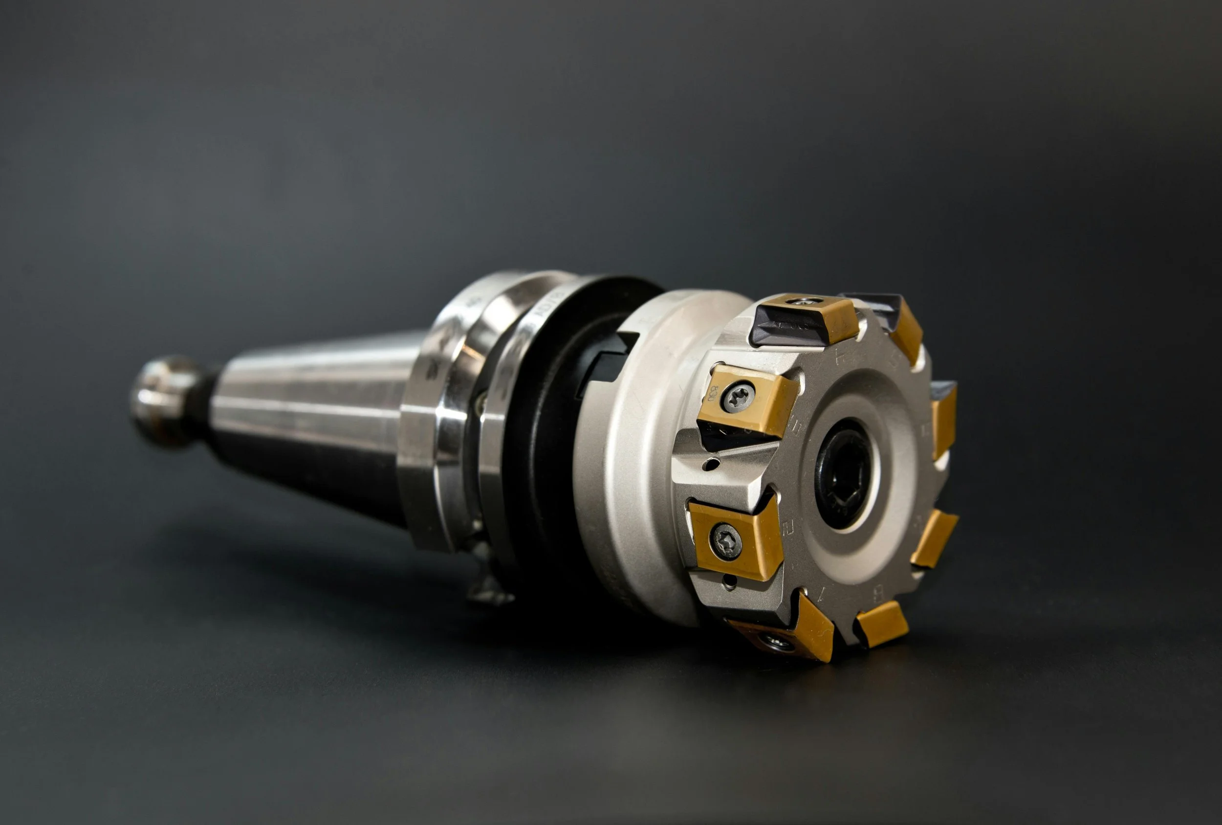 A CNC milling machine tool holder with indexable cutting inserts against a black background.