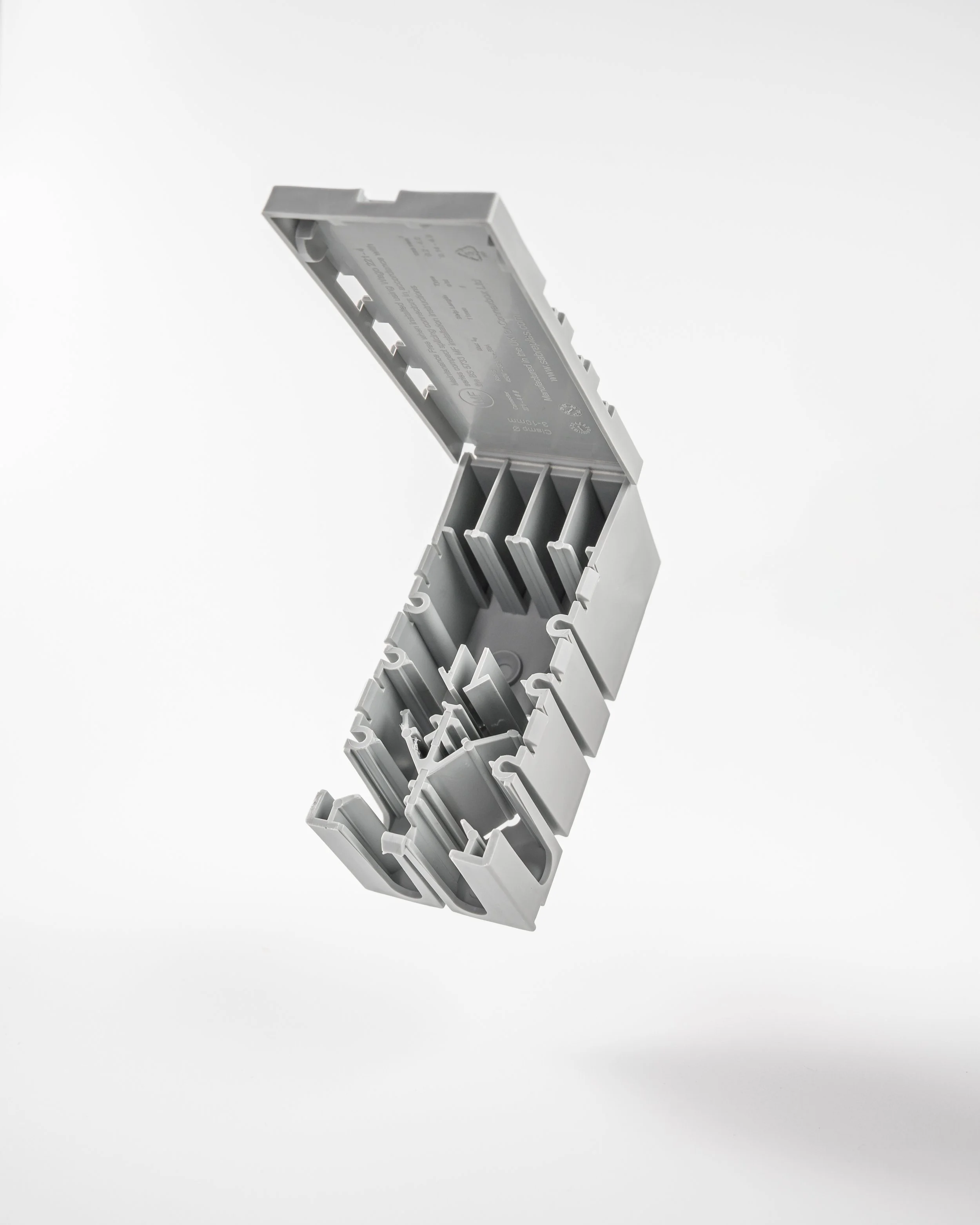 Gray plastic electrical box with open cover and multiple slots, floating against a white background.