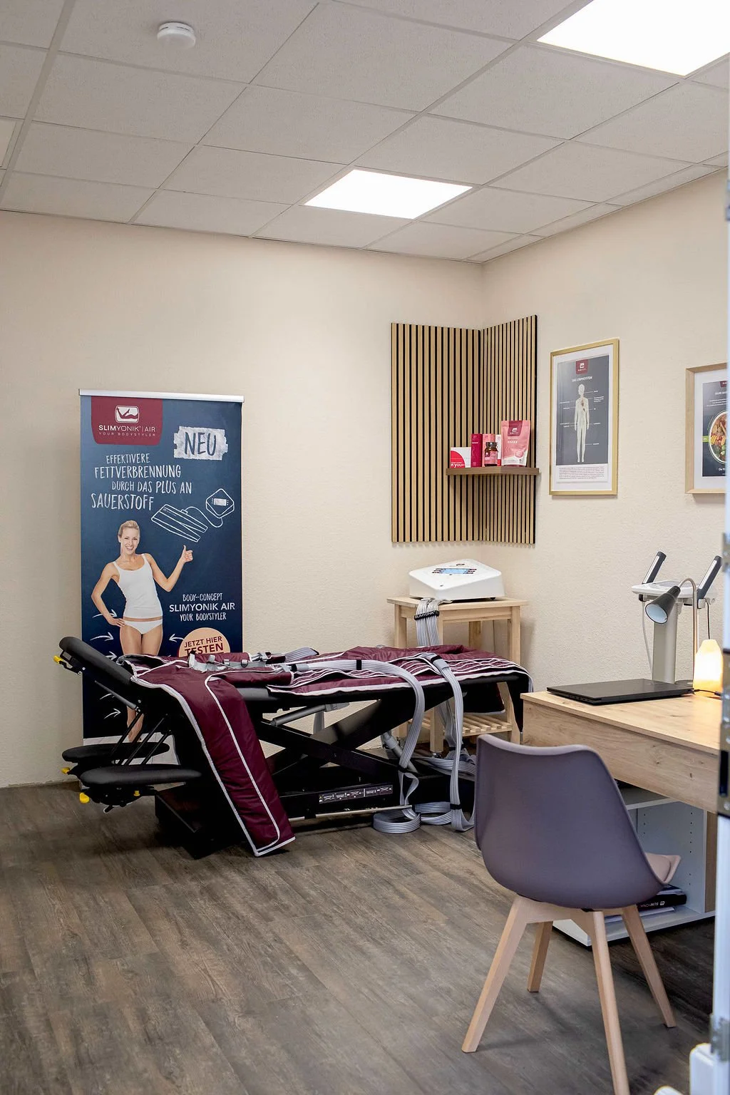 Behandlungsraum im Therapiezentrum Rohan mit Slimyonik-Liege und Kompressionsanzug