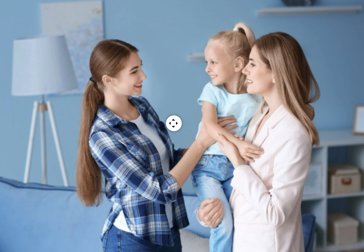 A woman, a young girl, and a woman are happily interacting indoors in a cozy, blue-themed room.