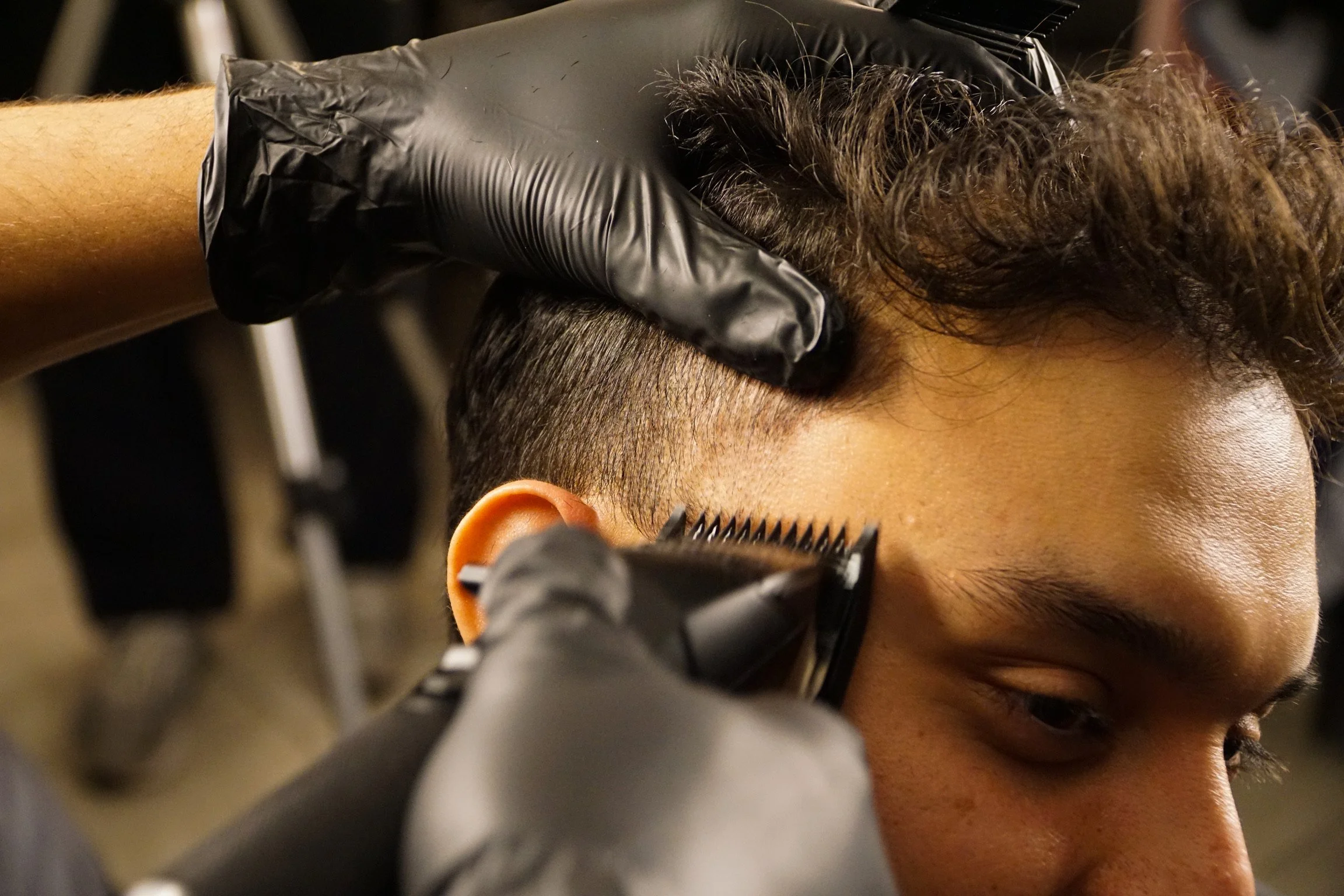 Black hair pick with wide teeth lying on a white surface.