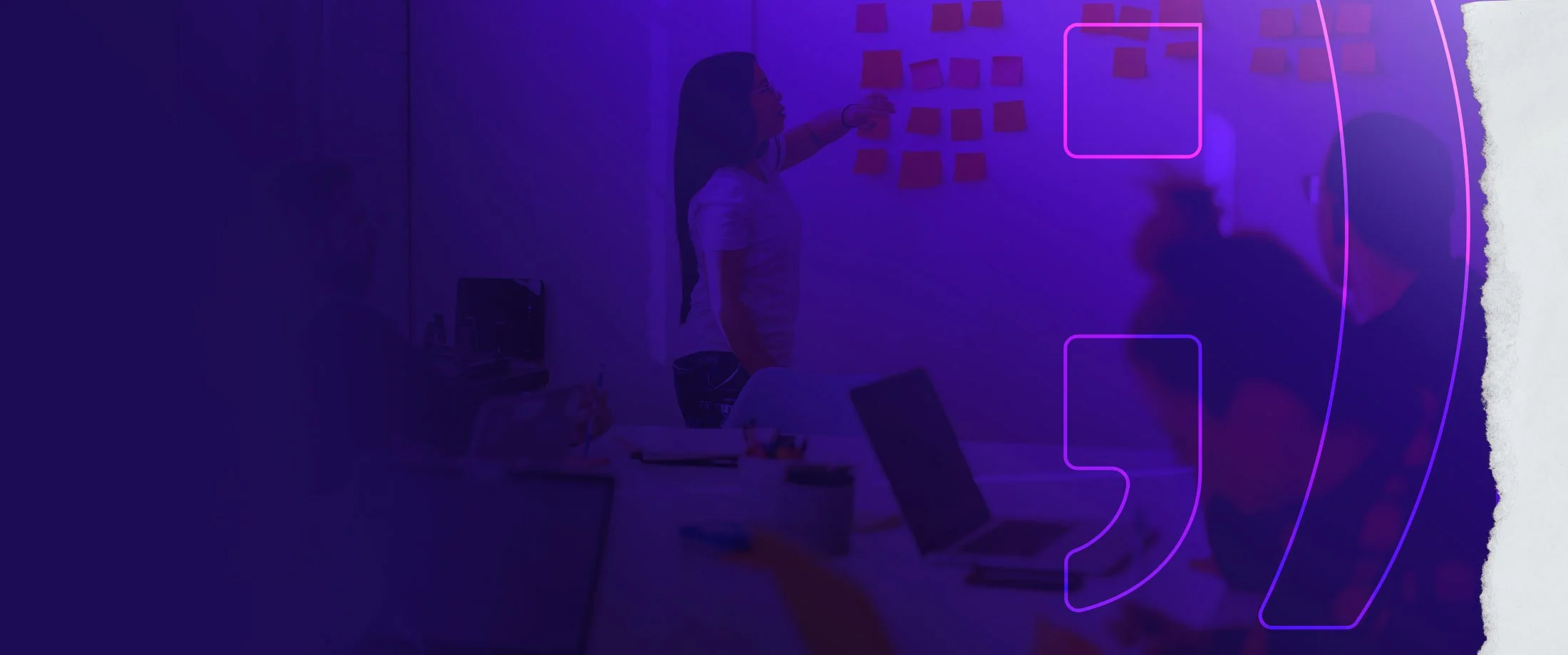 People working together on sticky notes in a classroom or office with purple lighting and digital outlines of a phone and square frames