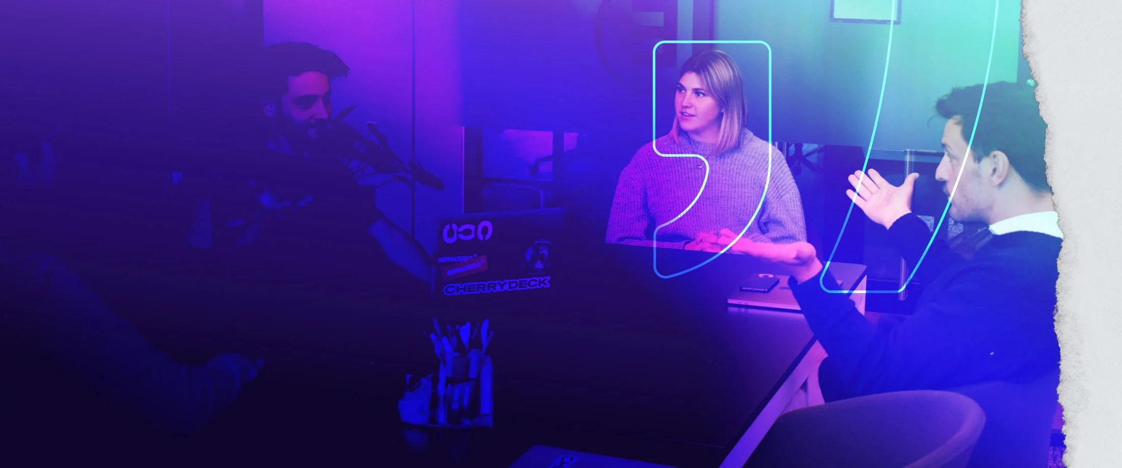 Three people having a discussion at a table in a dimly lit room with purple and blue lighting, with digital graphics overlayed.