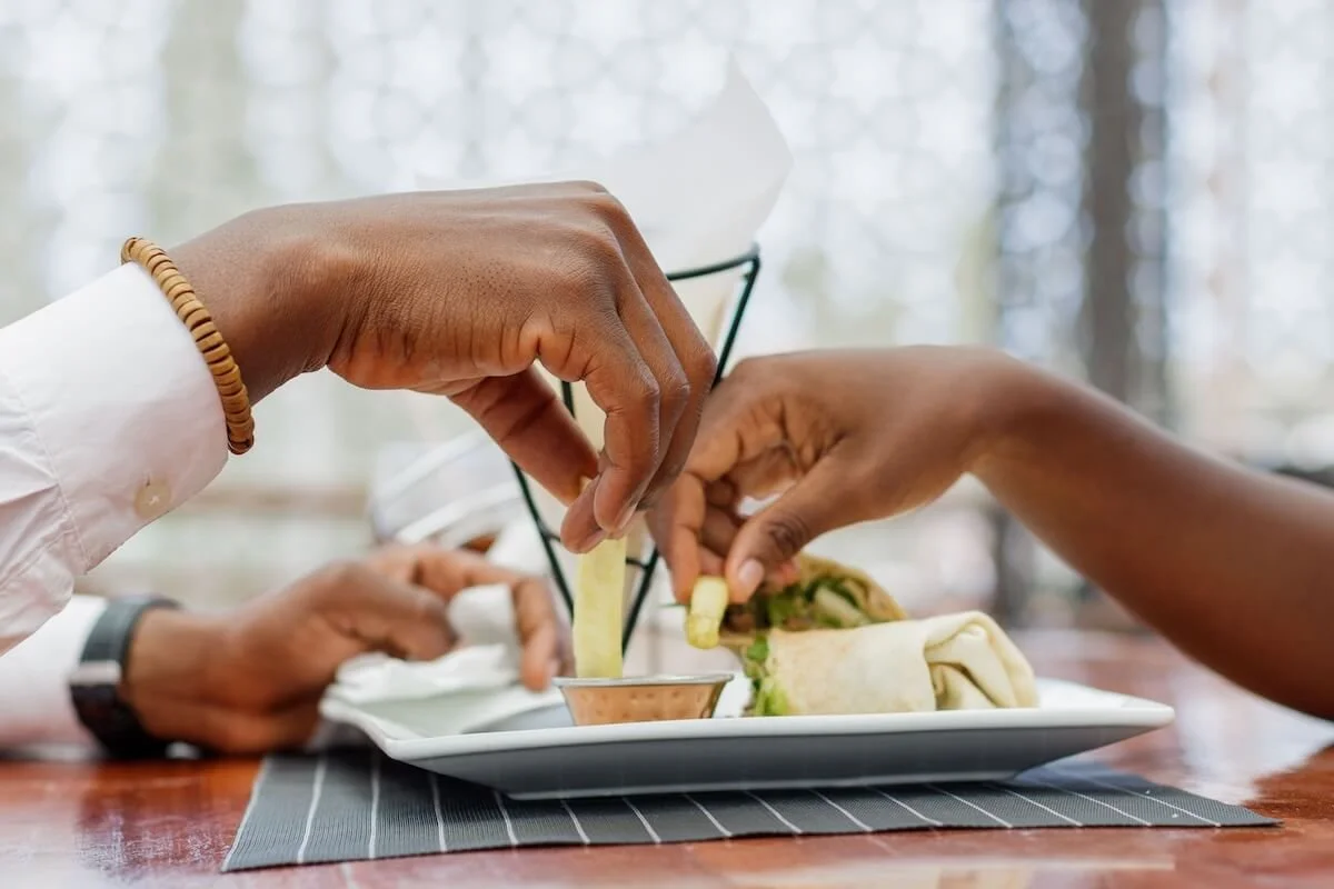 Two partners share a meal together, capturing the simple, intentional connection of a date that a St. Louis couples therapist and couples counselor in St. Louis help partners make time for again.