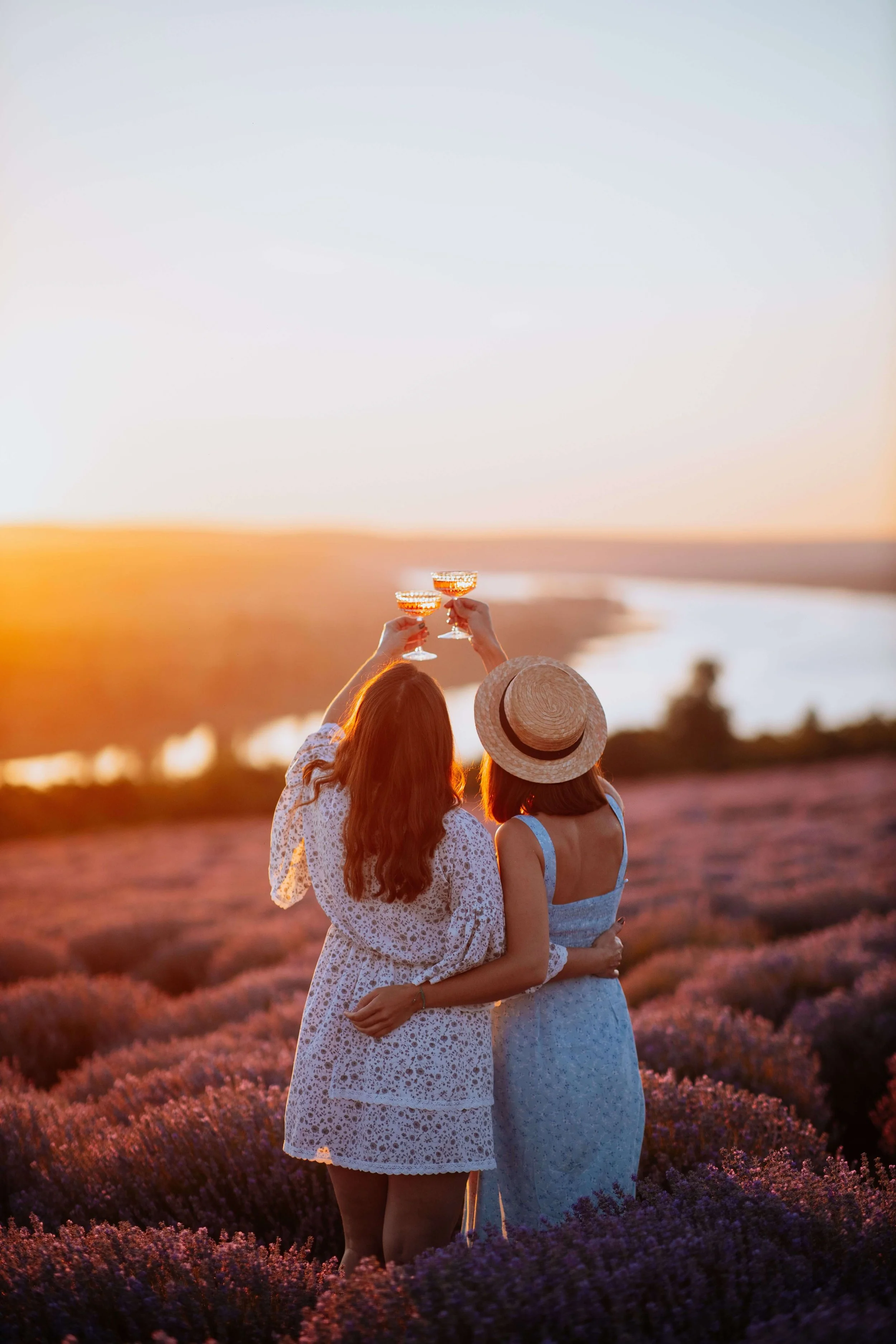 Two women raise a toast together in a lavender field at golden hour. What healthy habits should couples build into their relationship? Couples counseling in St. Louis, MO can help partners create lasting changes together.