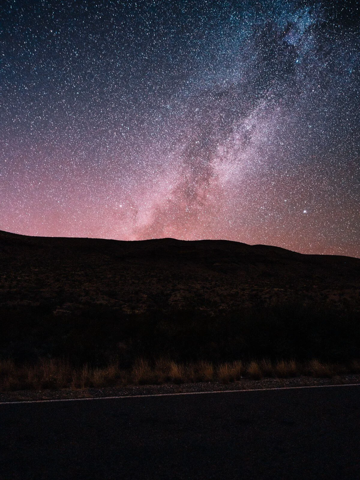 The Milky Way glows in shades of pink and purple above a quiet, dark hillside. How can couples rebuild intimacy once they've drifted apart? Couples counseling in St. Louis, MO can help guide partners back to each other.