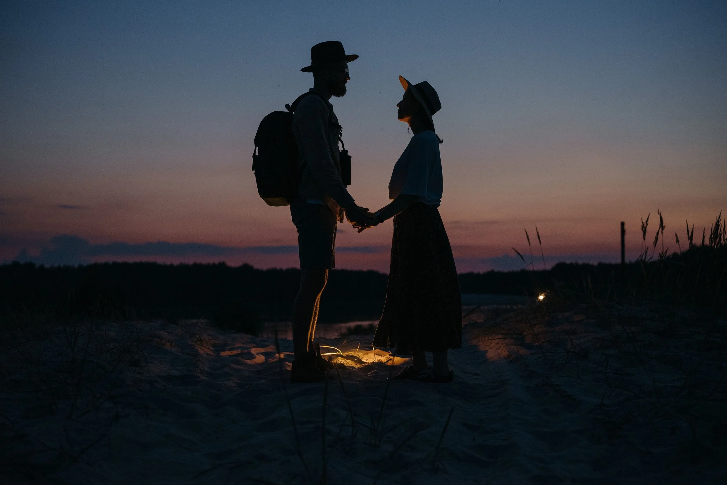 A couple stands silhouetted against a sunset, holding hands on a quiet beach. How can couples stay connected amid busy schedules? A couples counselor in St. Louis, MO can help partners prioritize meaningful time together.