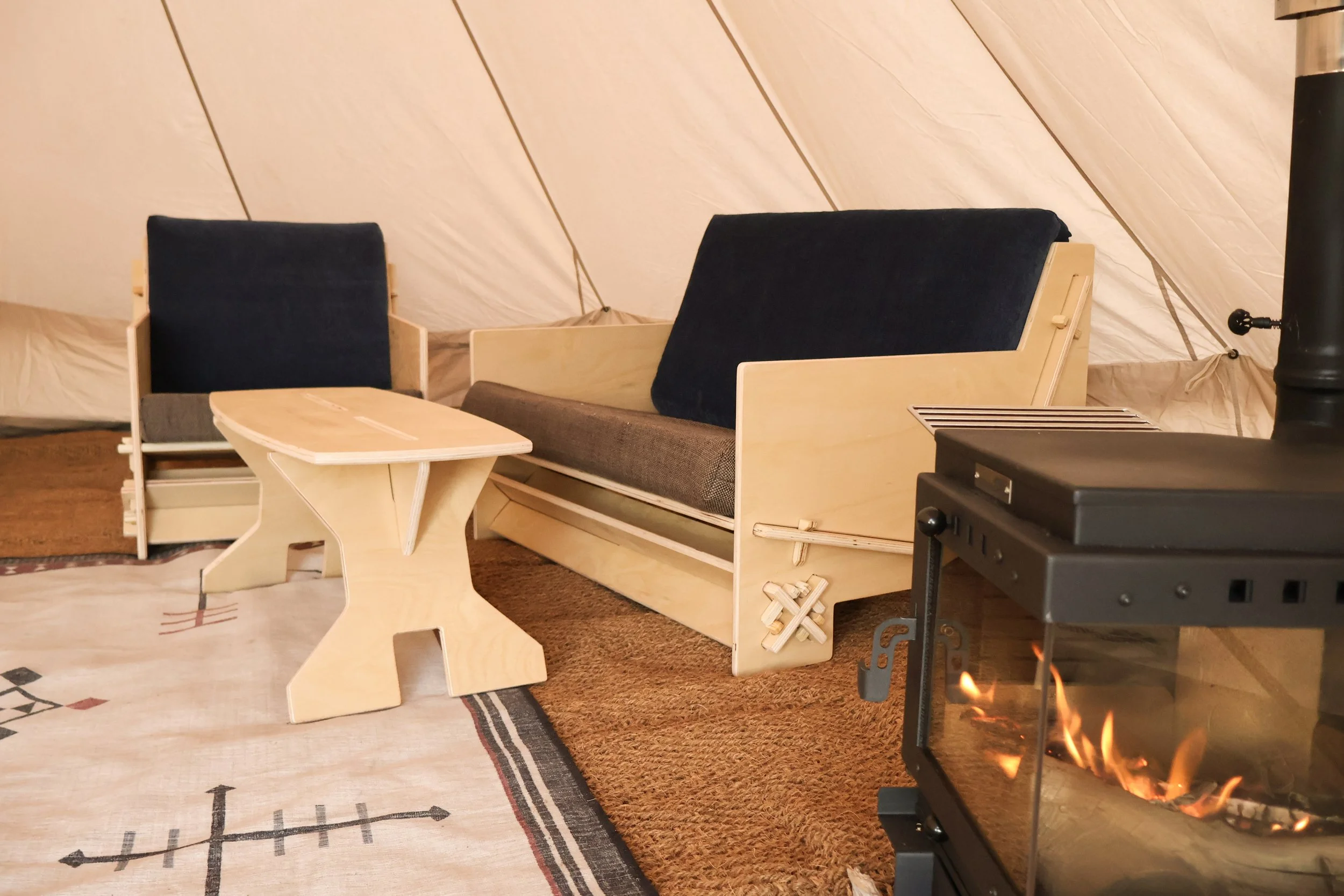 Flat-pack chair set inside a glamping tent Flat-pack chairs arranged in a glamping tent