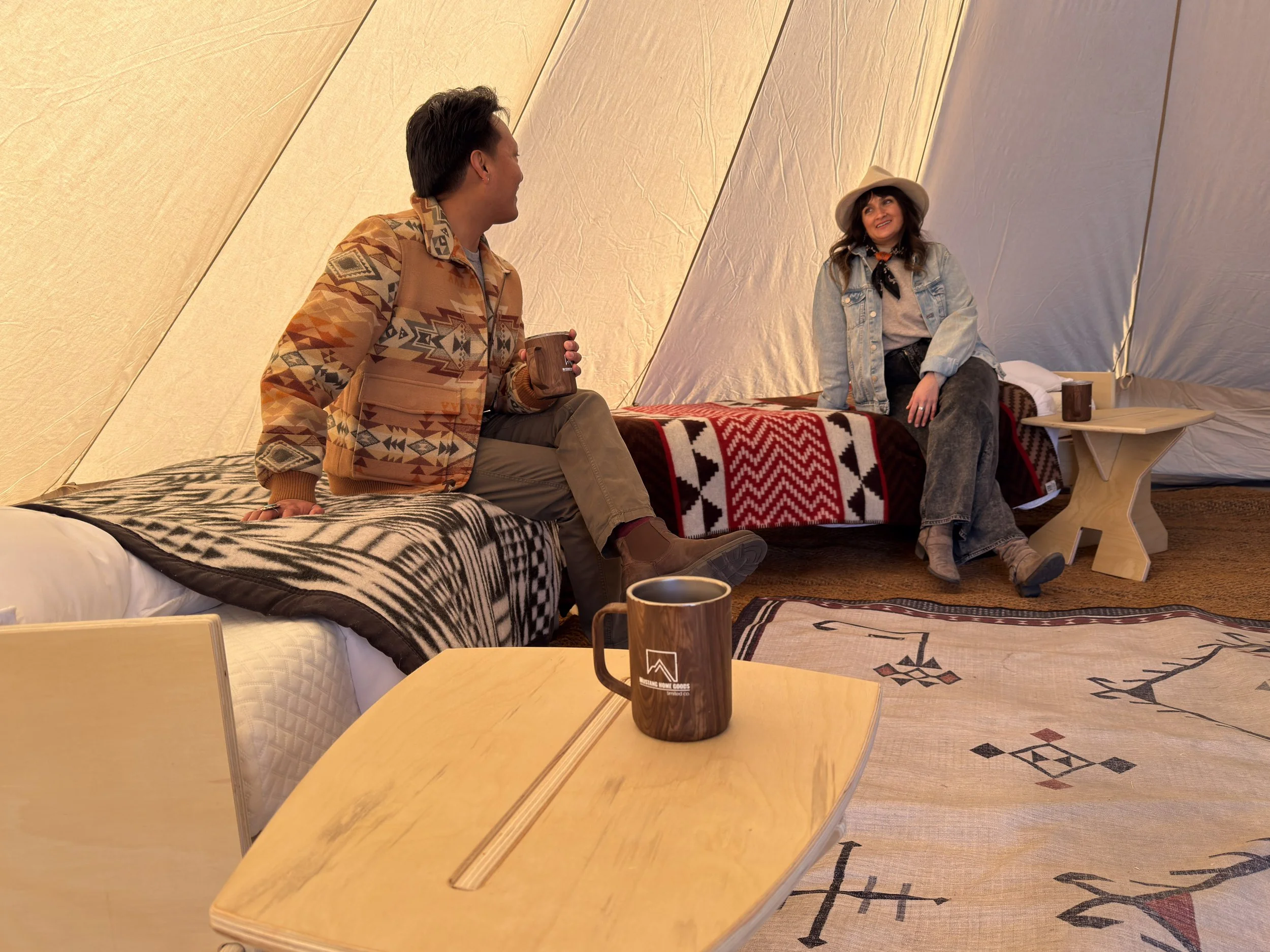 Guests enjoying a glamping tent featuring stylish flat-pack furniture and modern interior design