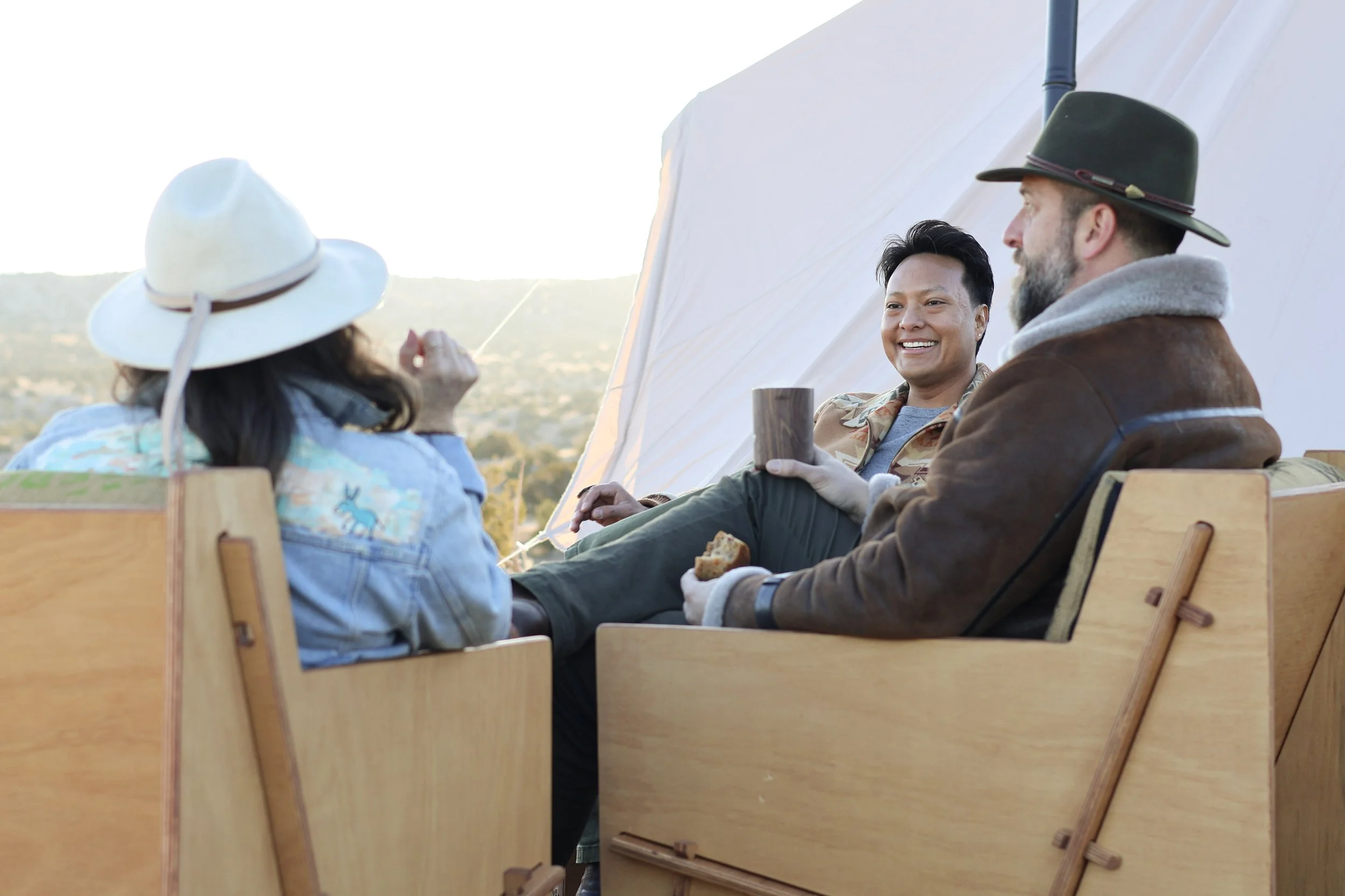 Friends enjoying an outdoor conversation while sitting on Mustang Home Goods chairs.