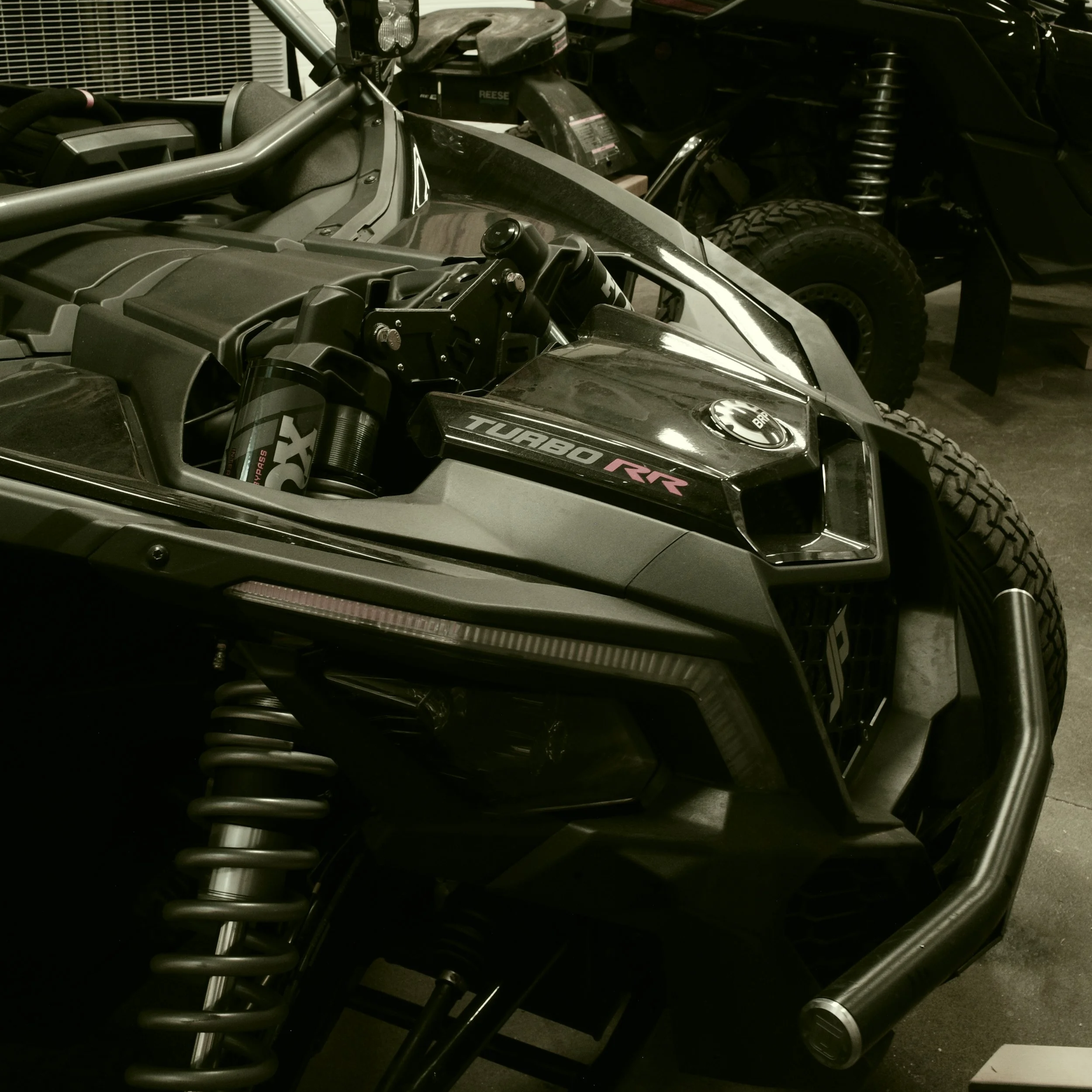 Close-up of a Polaris RZR Turbo side-by-side off-road vehicle in a garage.