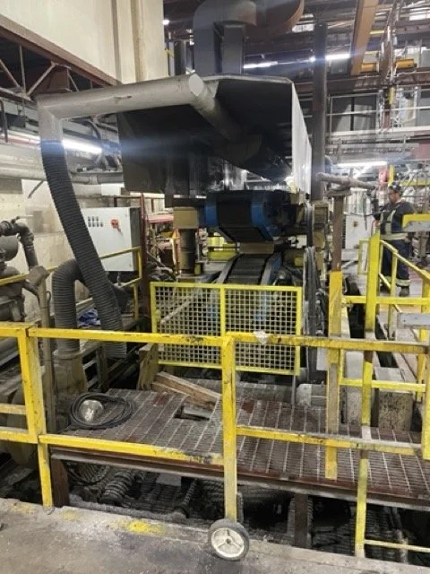Industrial machinery with yellow safety railings in a manufacturing plant.