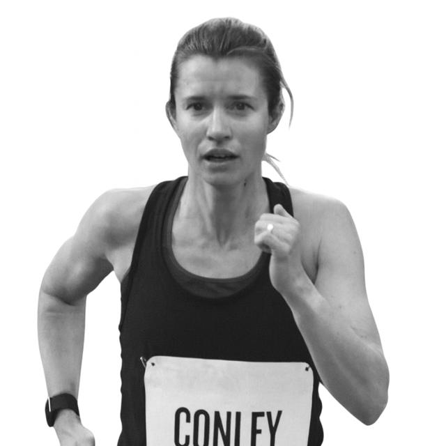 Black and white image of a woman running, wearing a sports tank top with the name 'Conley' on her bib, looking determined and focused.