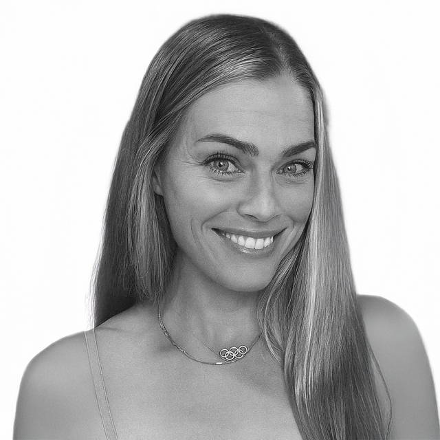 Black and white portrait of a smiling young woman with long hair, wearing a necklace and a spaghetti strap top.