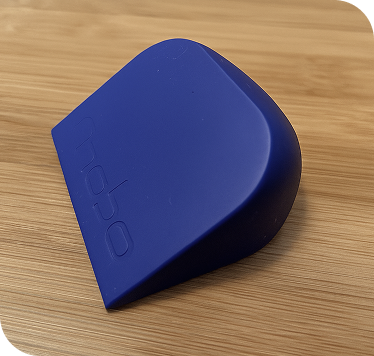 A blue rectangular electronic device with rounded edges on a wooden surface.