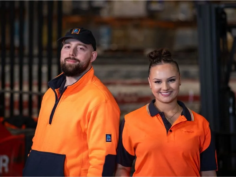 Industrial workers wearing durable high-visibility workwear uniforms.